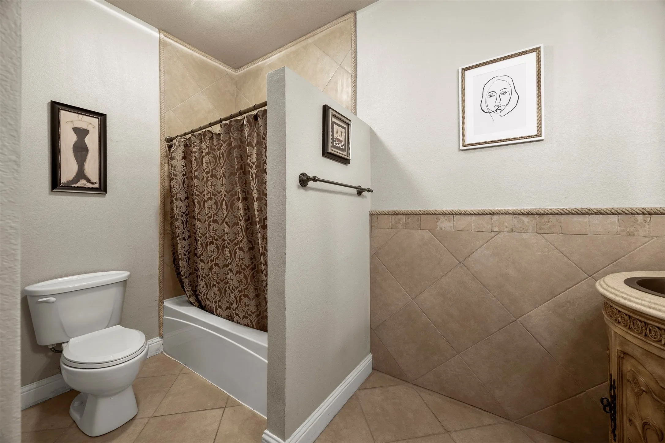 Private ensuite bathroom featuring custom tilework, elevated vanity finishes, & a tub-shower combination for added comfort & convenience.