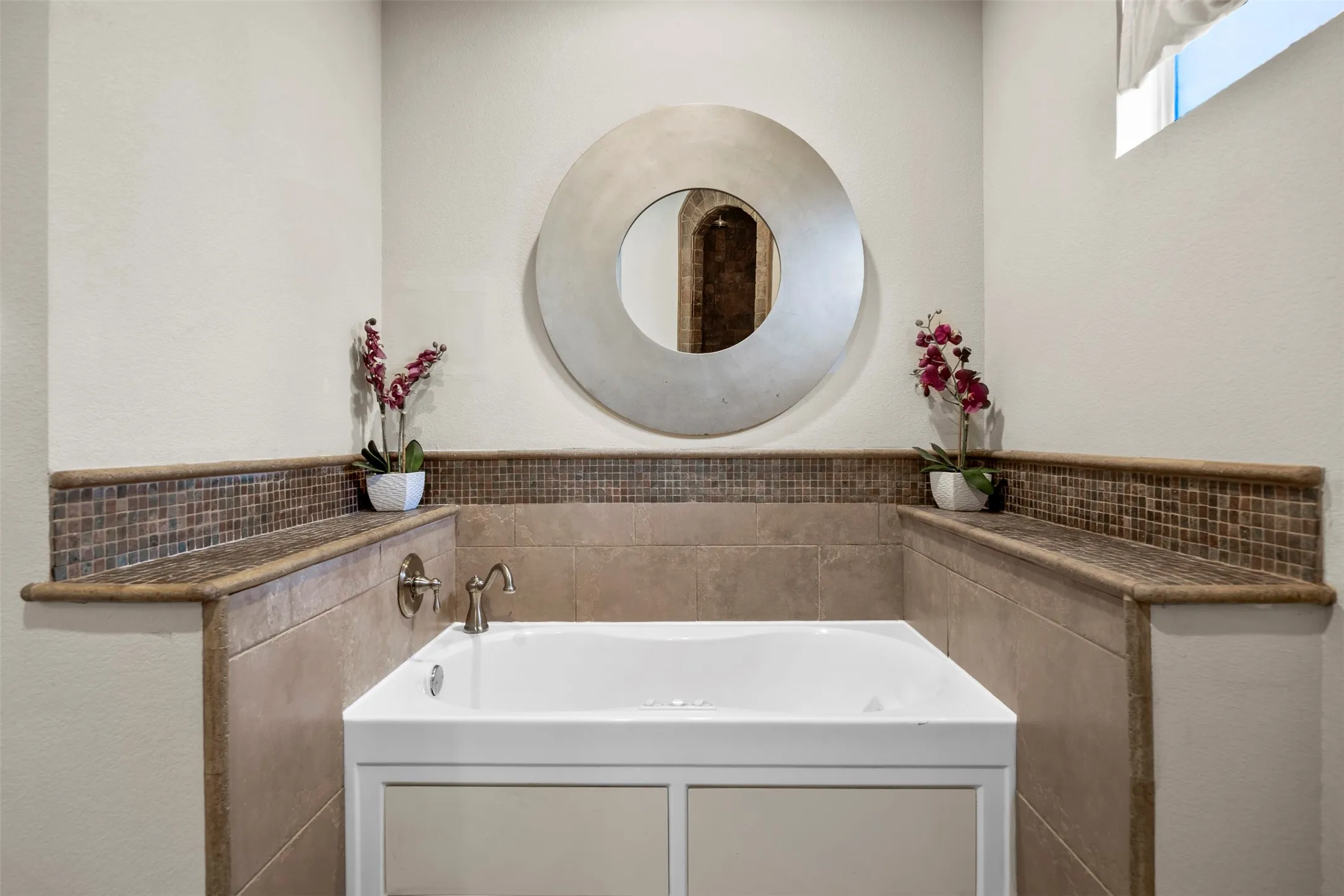 Spa-inspired private soaking jetted tub, custom tile surround, & peaceful retreat-like atmosphere designed for relaxation.