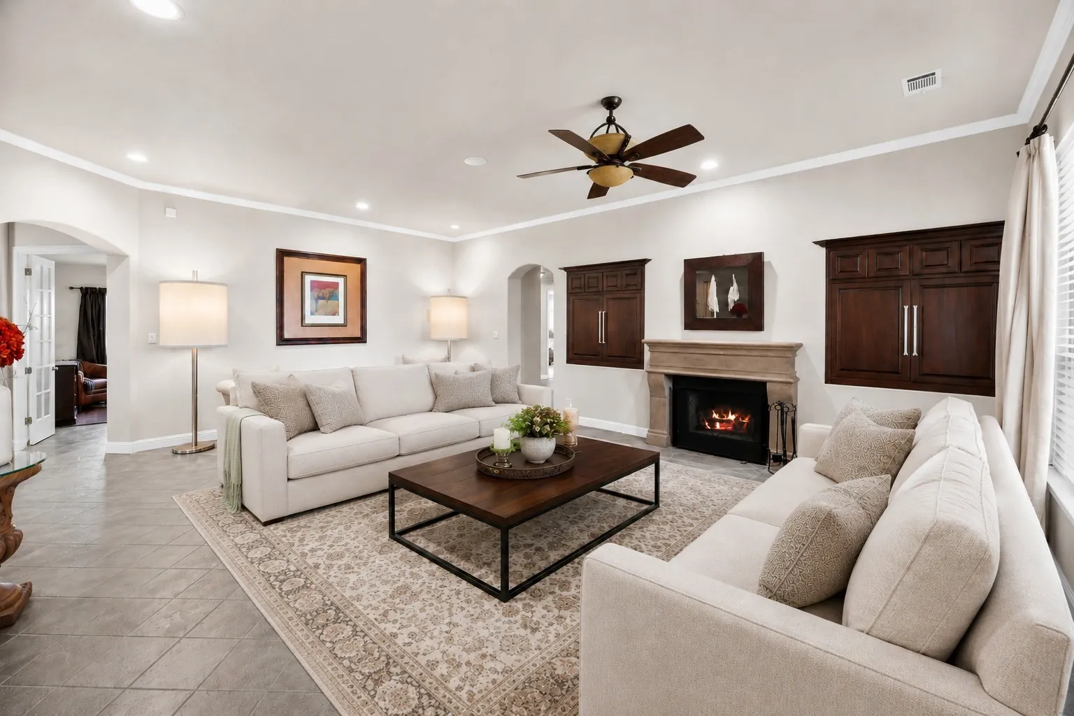 Family living room with a wood burning fireplace and abundant natural light. (virtually staged)