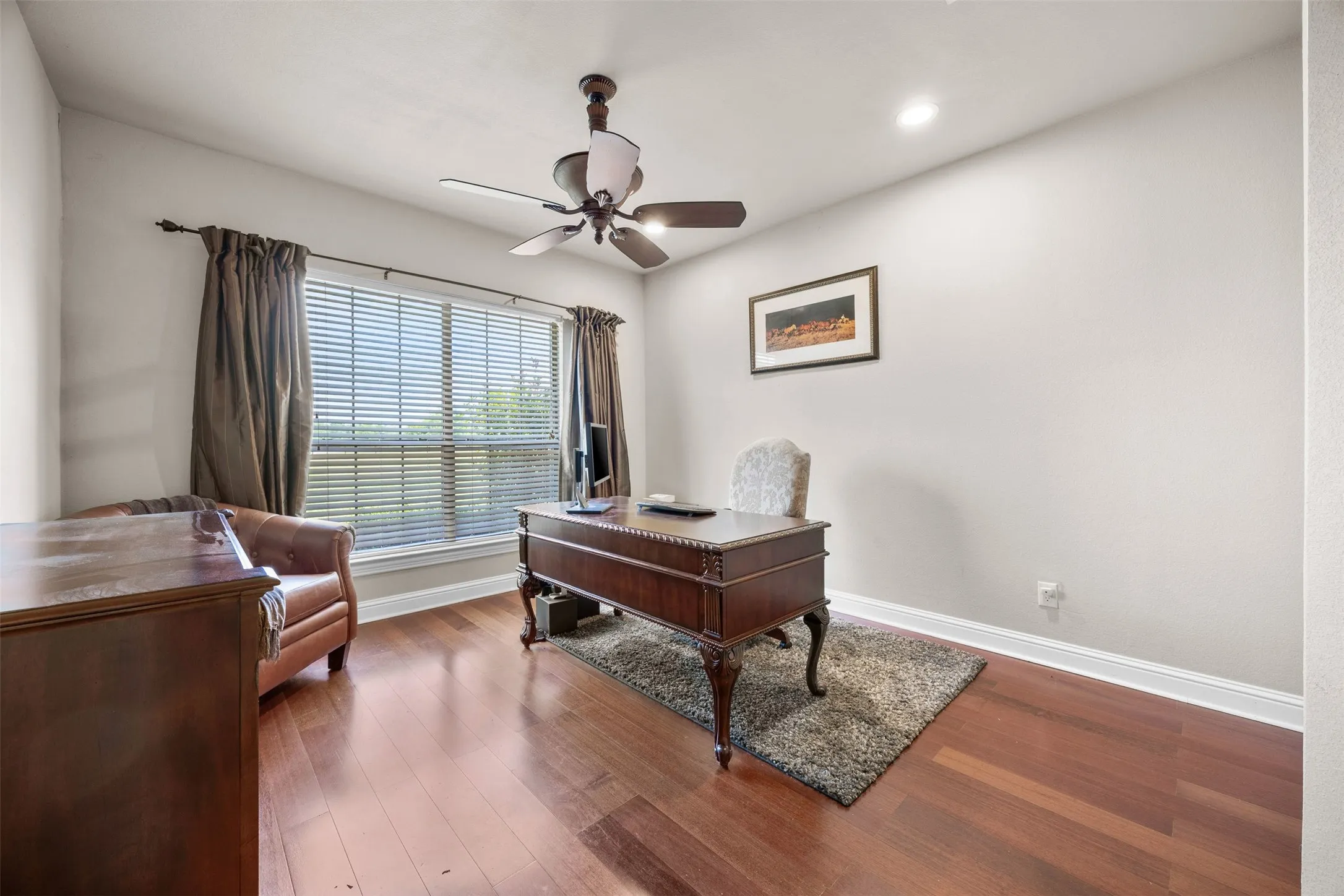 Dedicated office located off the front entry featuring hardwood floors, large front-facing window, & closet for added storage and functionality.