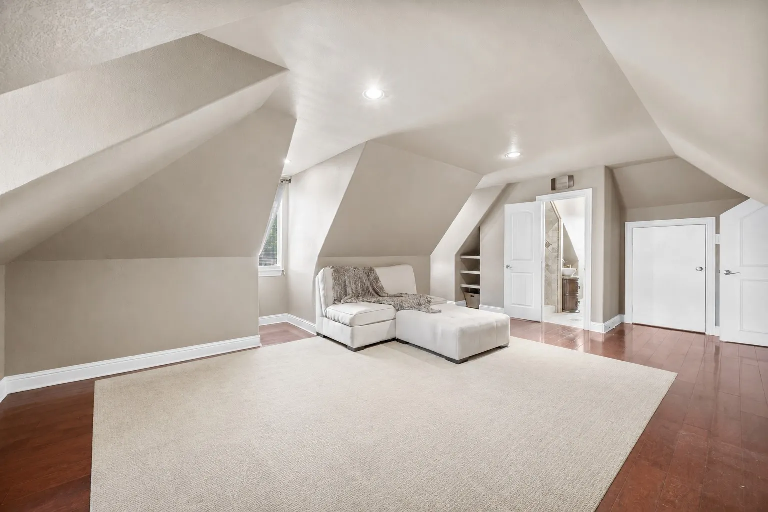 Oversized upstairs bedroom retreat with attached full bathroom offering endless flexibility as a bedroom, game room, media room, gym, or private guest suite. (virtually staged)