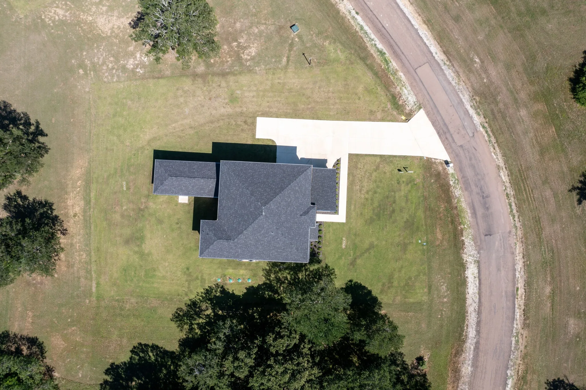 Single-story residence featuring a dark shingle roof and a concrete driveway