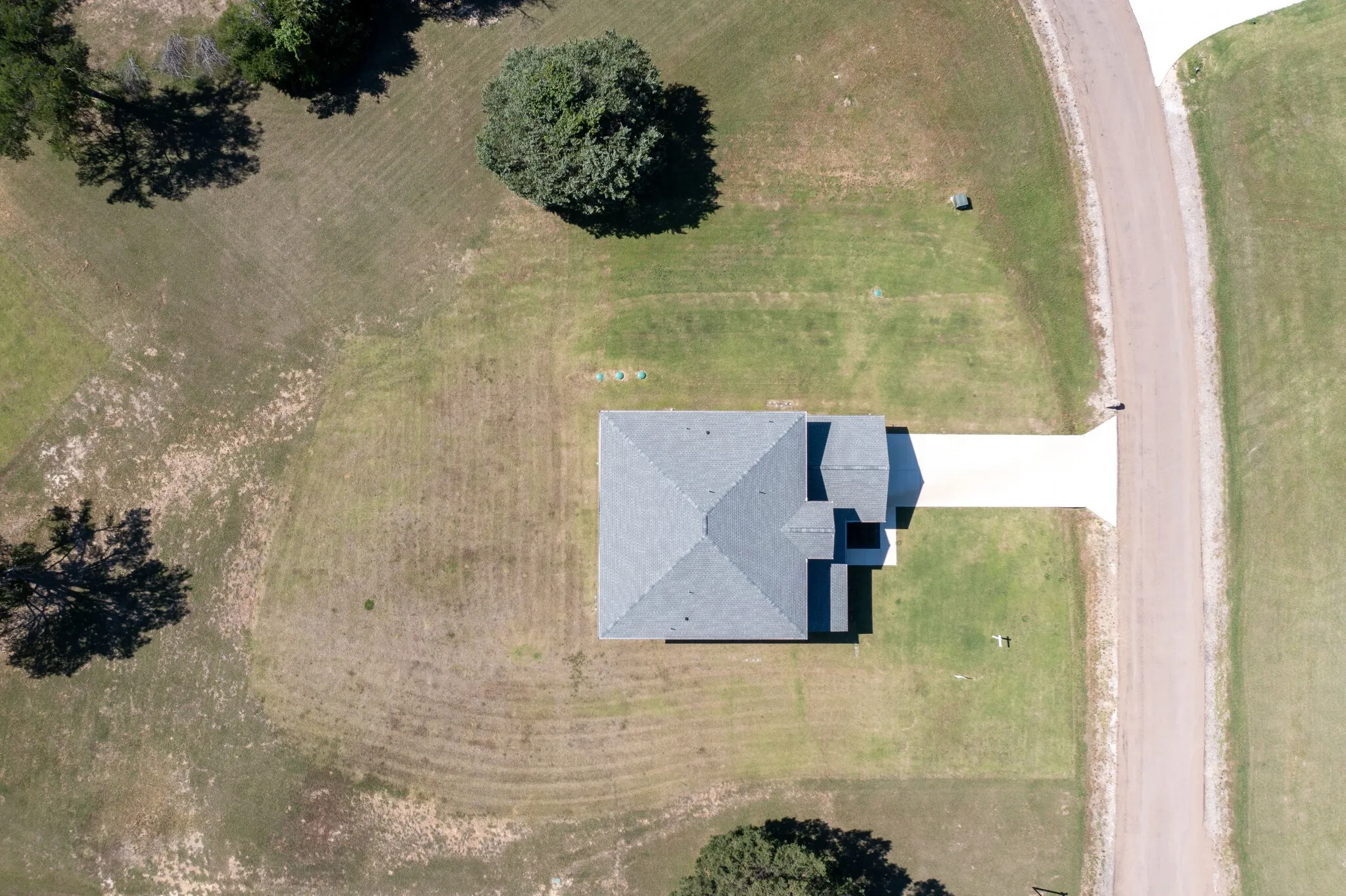 Single-story residence featuring a gray shingle roof and a concrete driveway