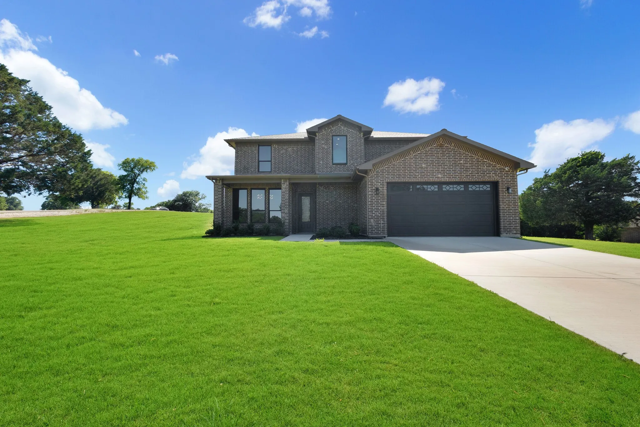 Two-story brick exterior with a dark-paneled garage door