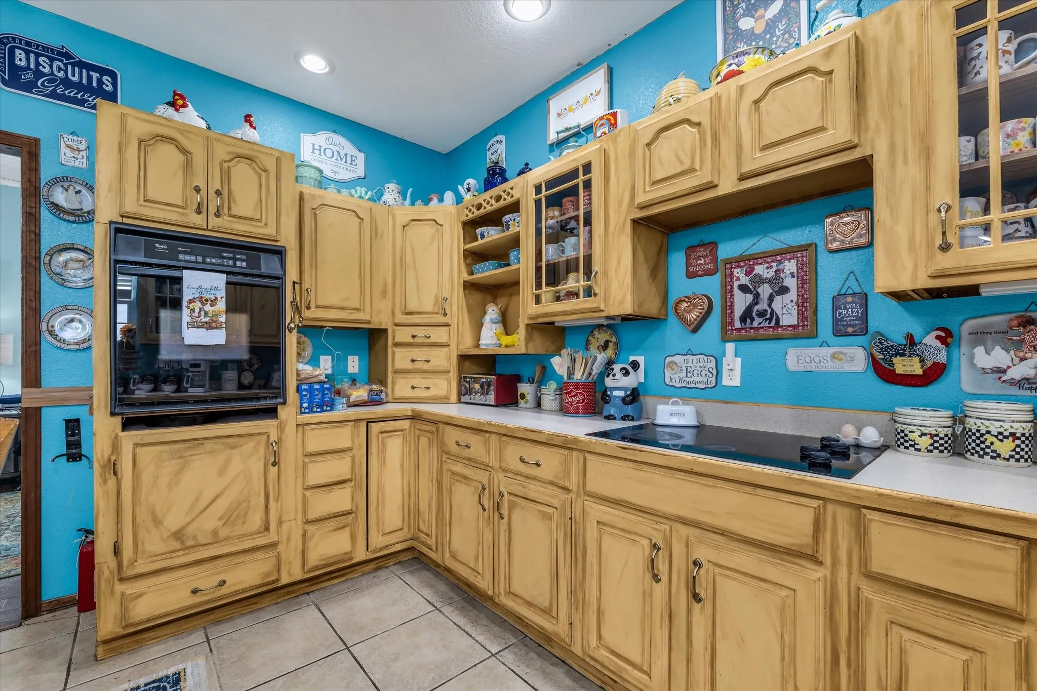 Kitchen featuring extensive cabinetry with wood-finish doors, a built-in oven, and an integrated cooktop