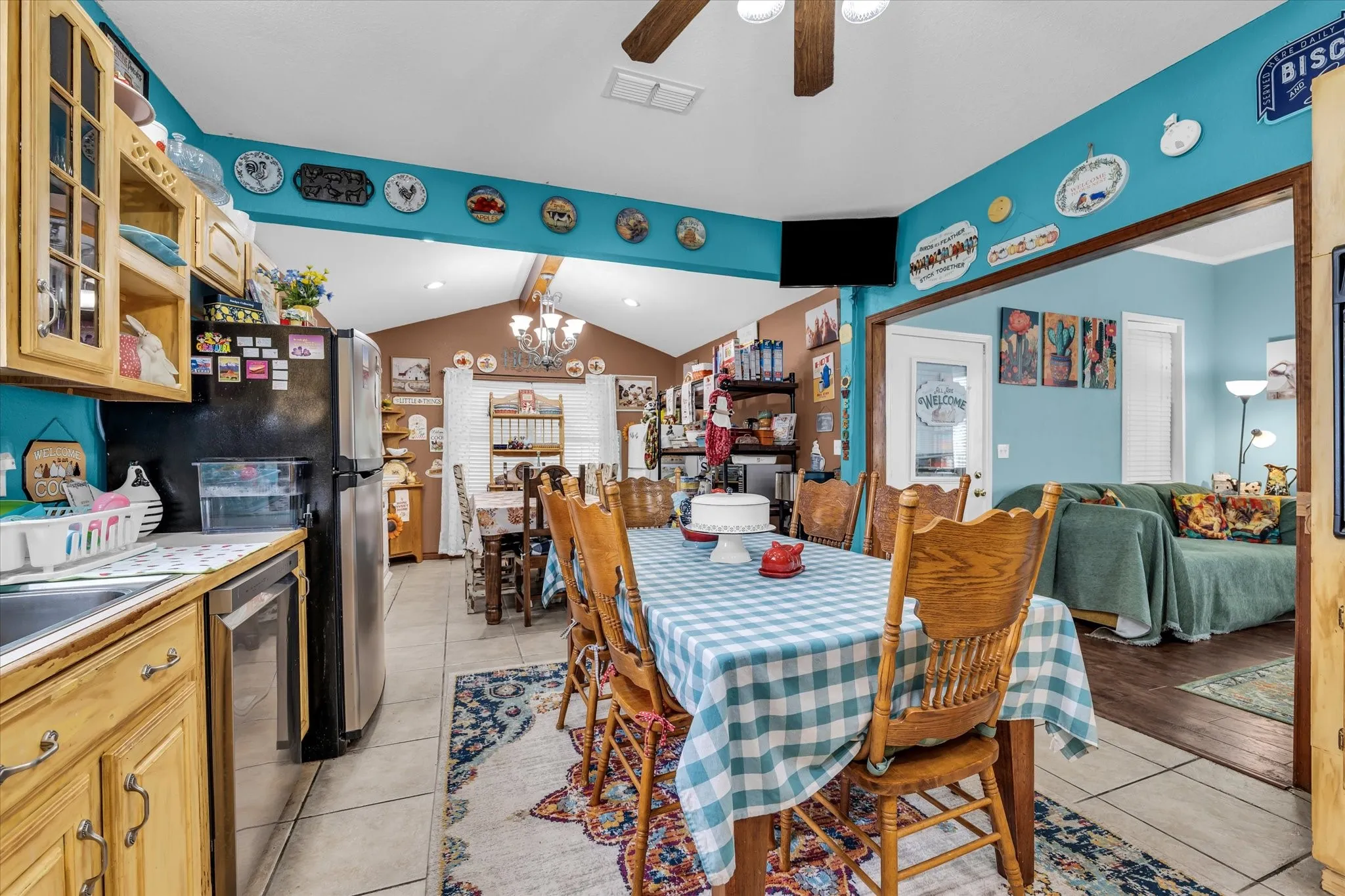 Kitchen and dining area featuring wood-finish cabinetry, stainless steel appliances, and a vaulted ceiling