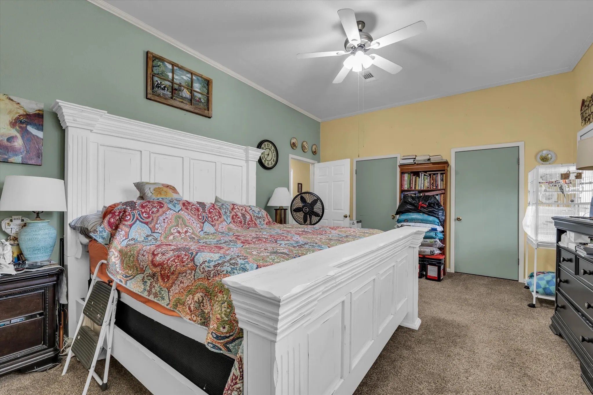 Bedroom featuring carpet flooring, two paneled doors, and a ceiling fan with integrated lighting
