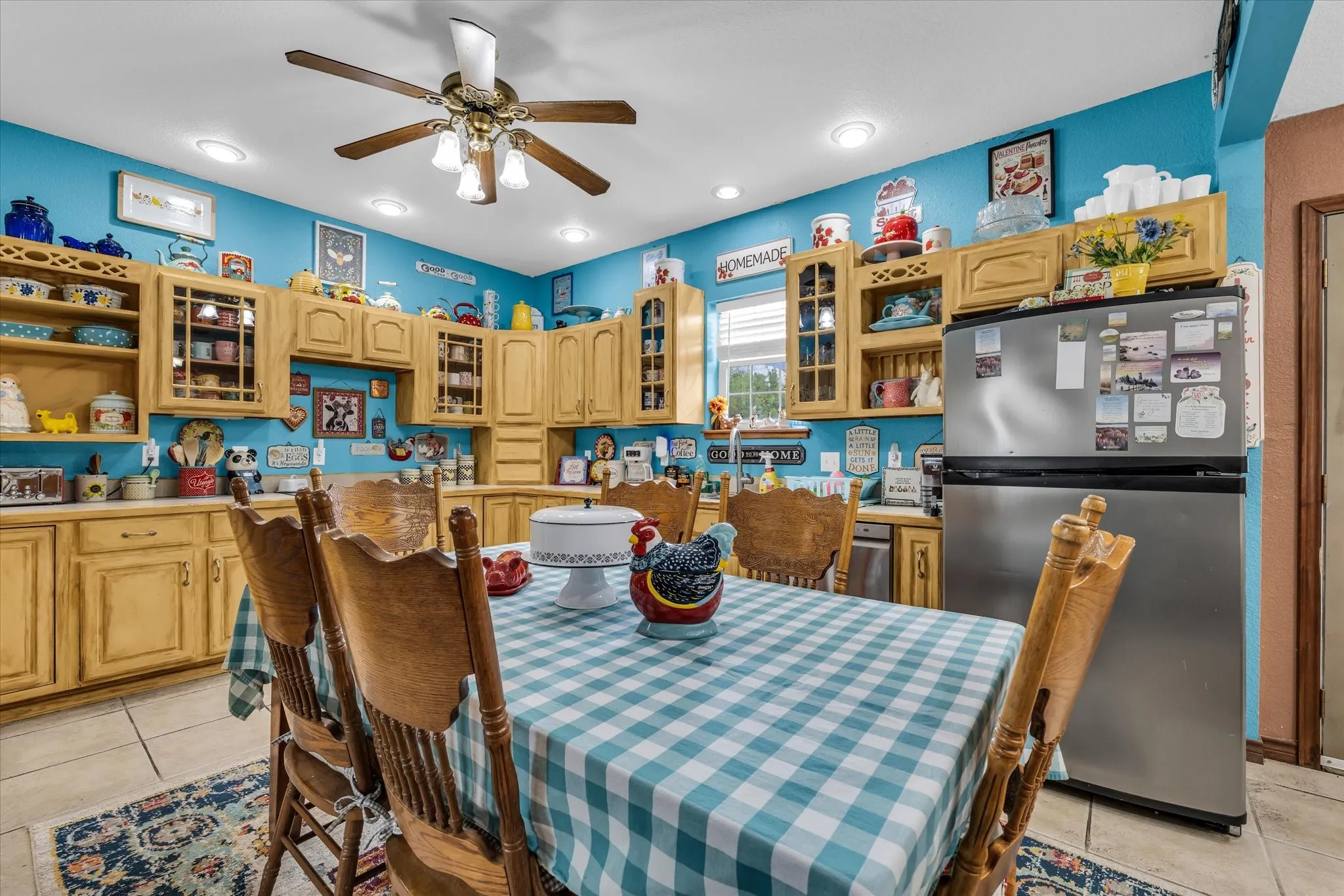 Kitchen featuring extensive light wood cabinetry, recessed ceiling lighting, a ceiling fan with light fixture, stainless steel refrigerator, and tiled flooring