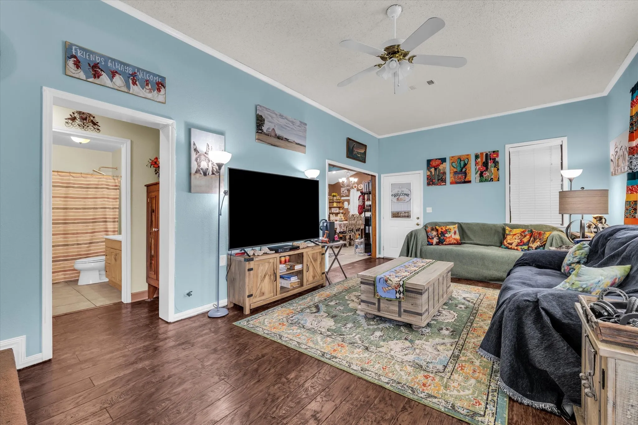 Spacious room featuring wood-finish flooring and a ceiling fan with integrated lighting