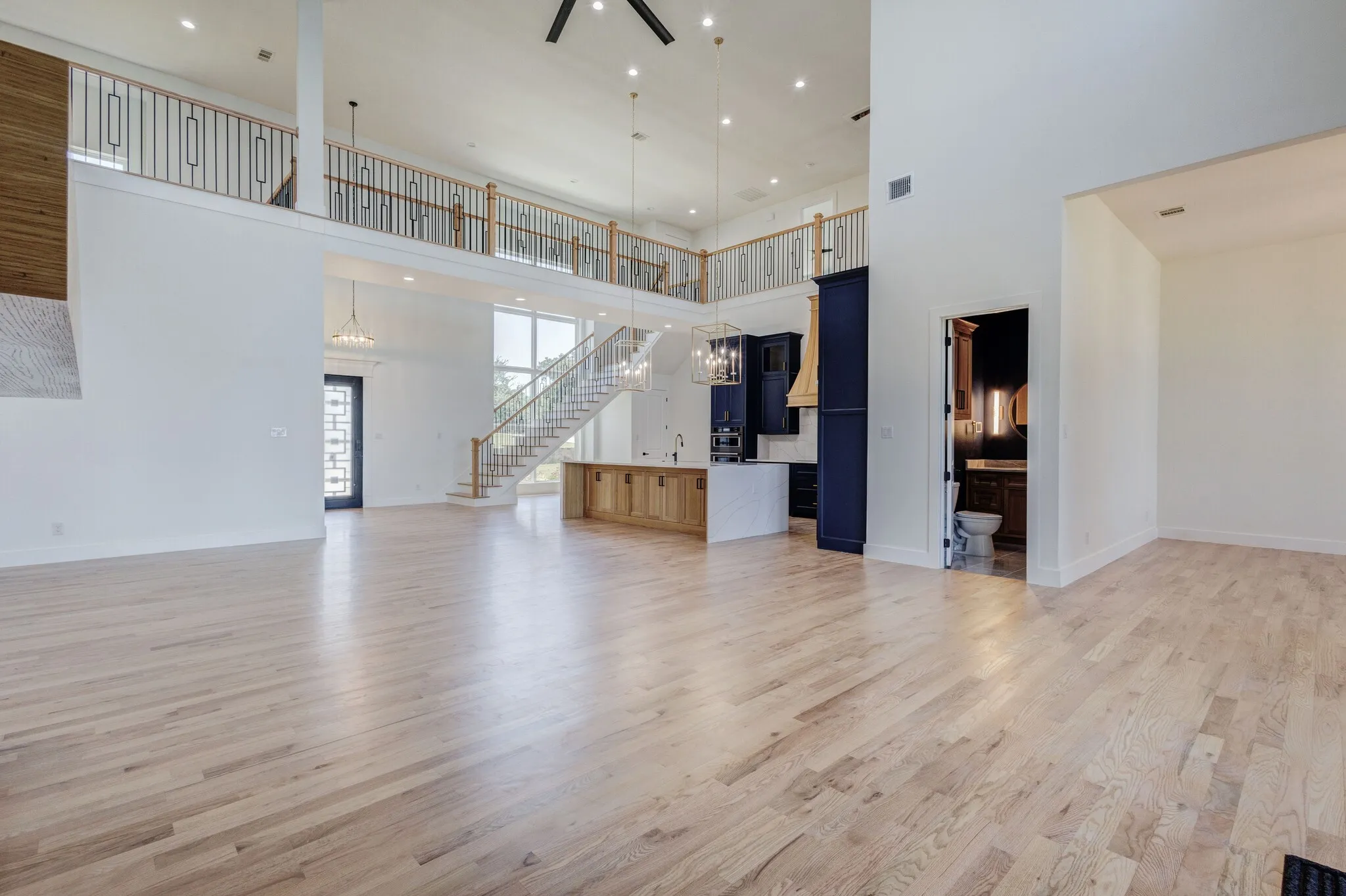 Expansive open-concept living area featuring light wood-finish flooring throughout
