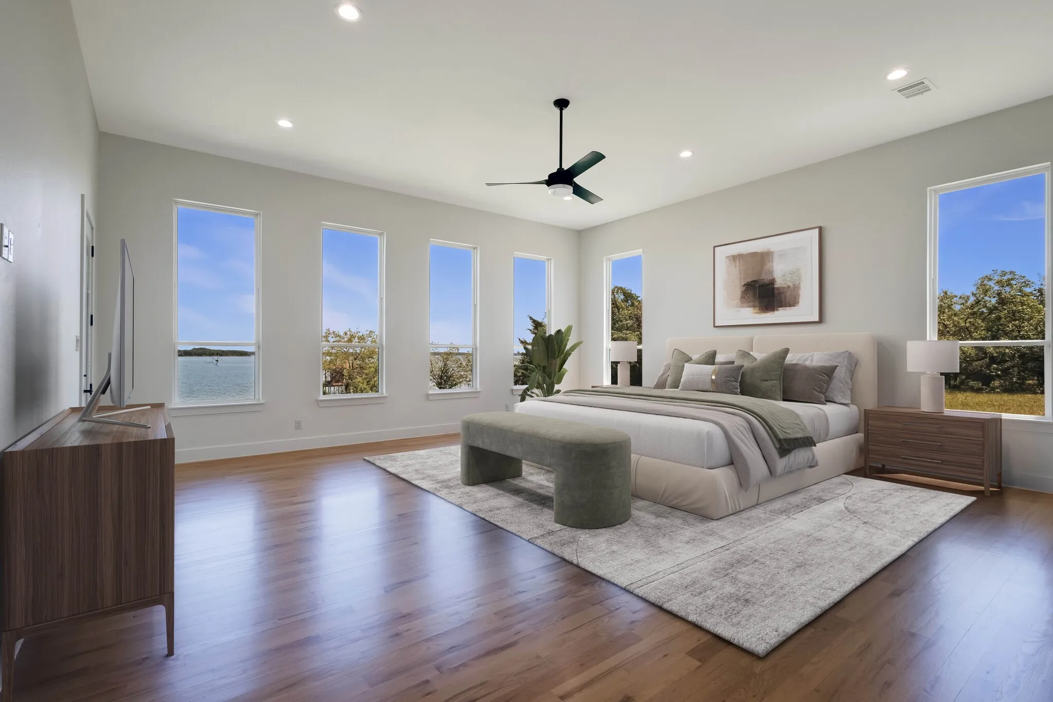Spacious room featuring multiple rectangular windows, wood-finish flooring, recessed lighting, and a ceiling fan
