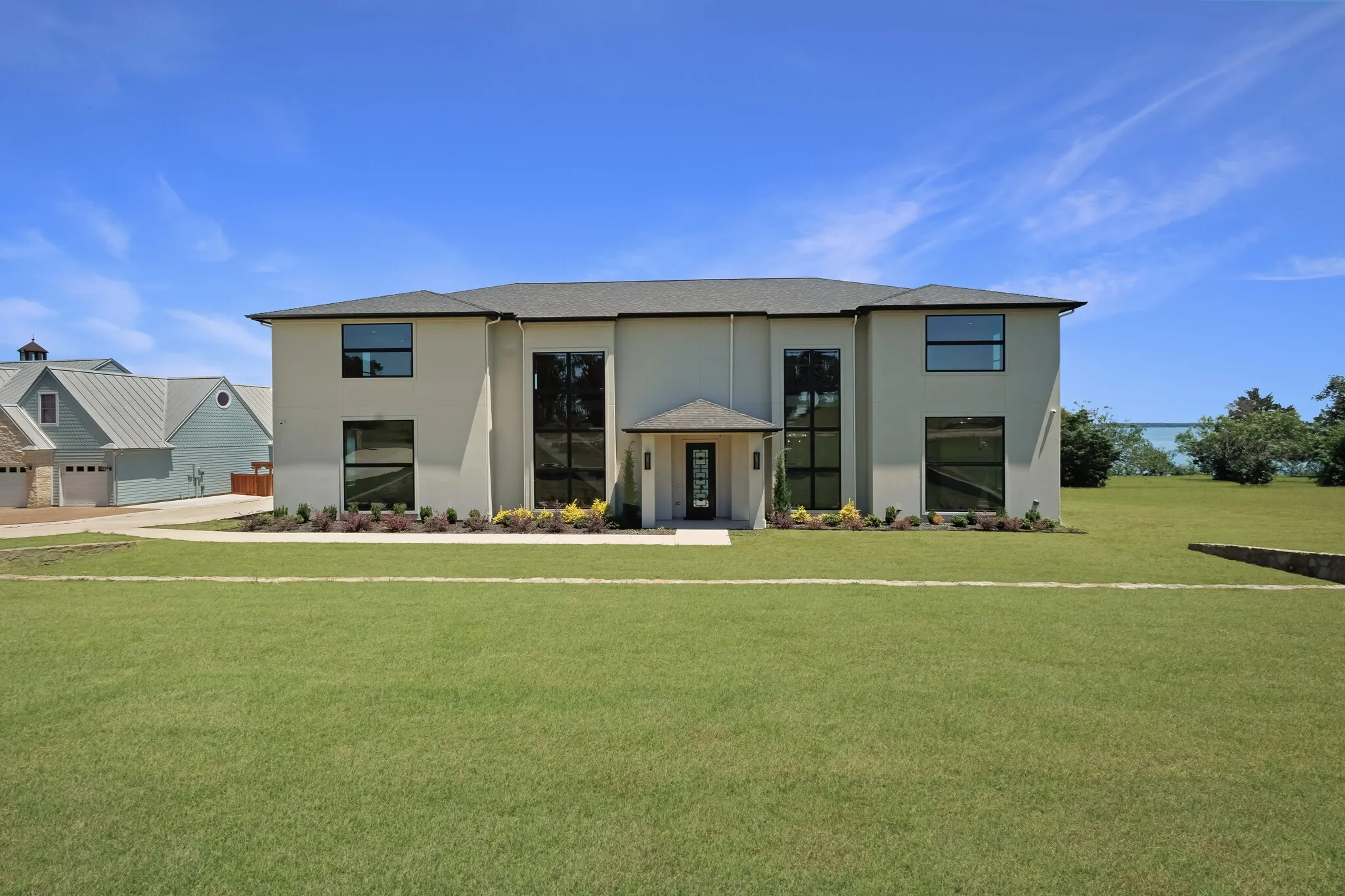 Contemporary two-story residence featuring a stucco exterior and prominent large-scale windows
