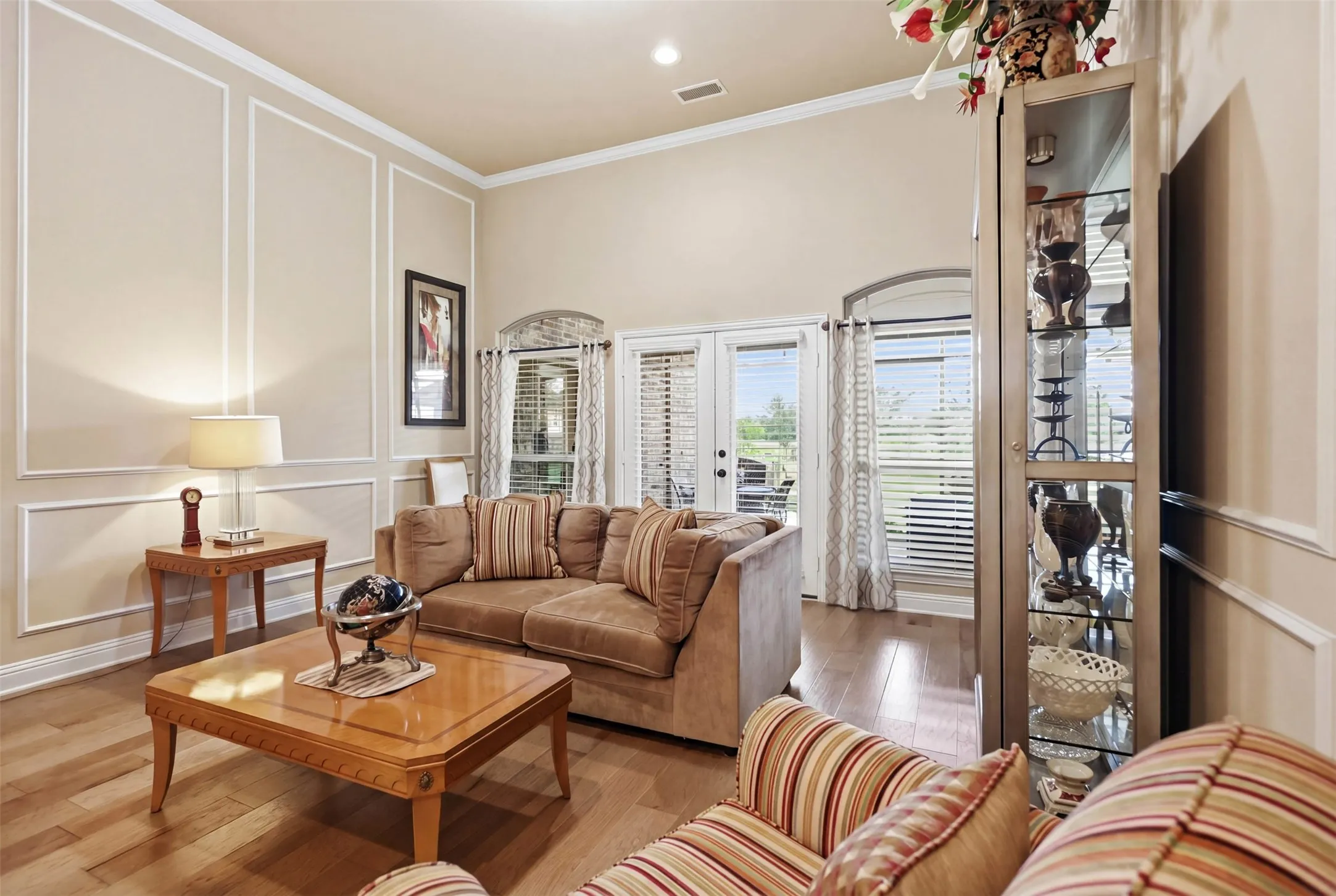 Living area featuring high ceilings, wood-finish flooring, and white wall trim