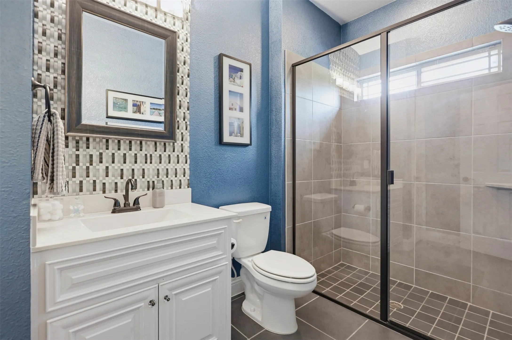 White vanity with fluted cabinet doors, integrated sink, and dark bronze-finish faucet