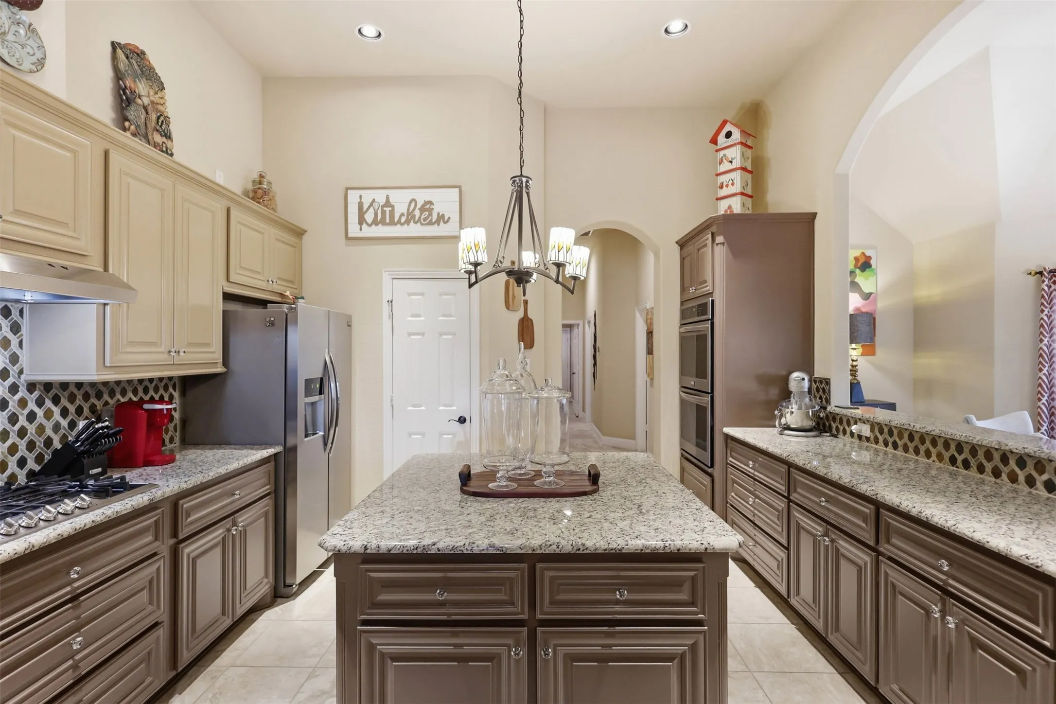 Kitchen featuring an island with granite countertops, recessed lighting, and a chandelier