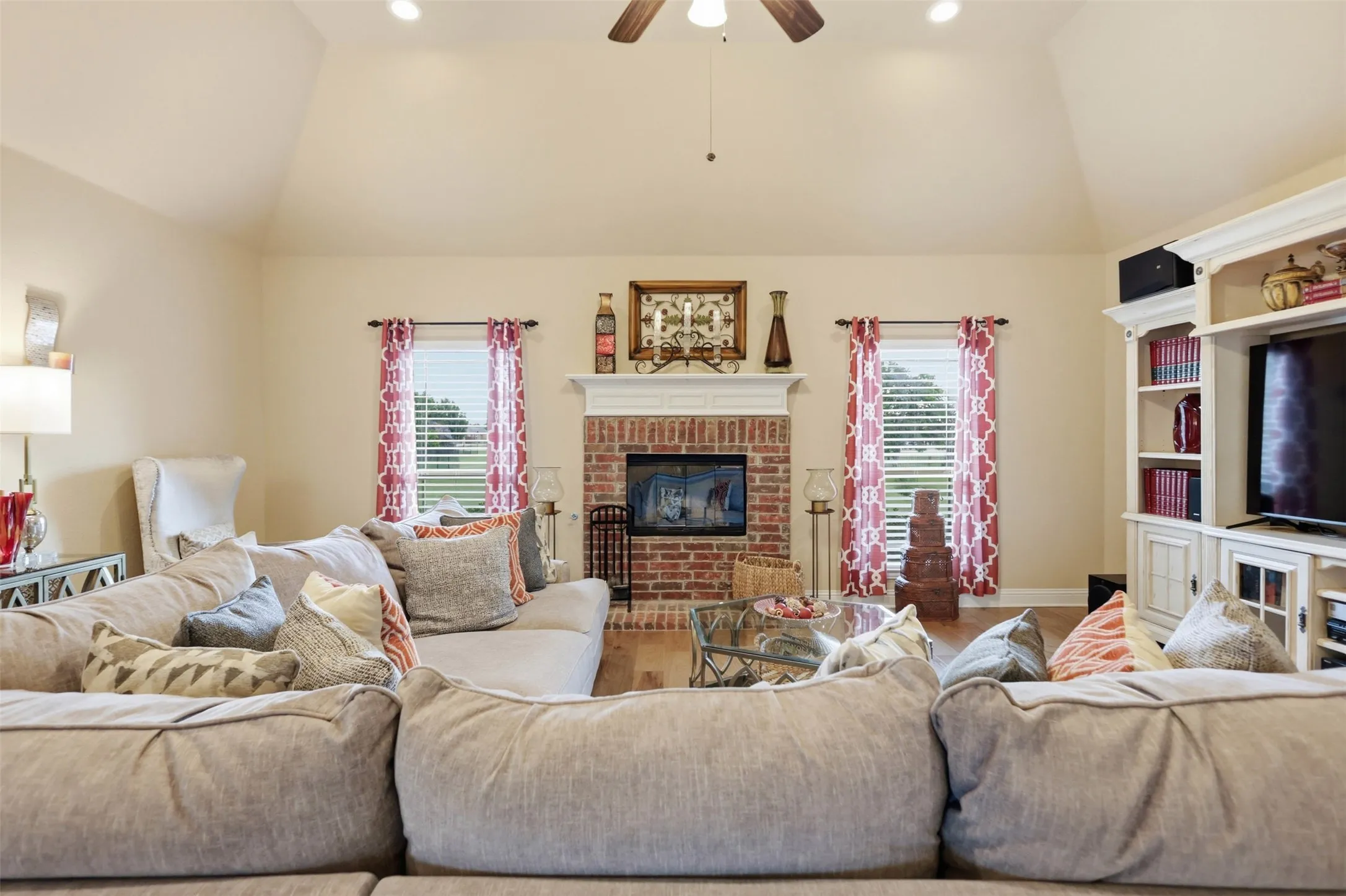 Spacious living area featuring a vaulted ceiling with recessed lighting and a ceiling fan