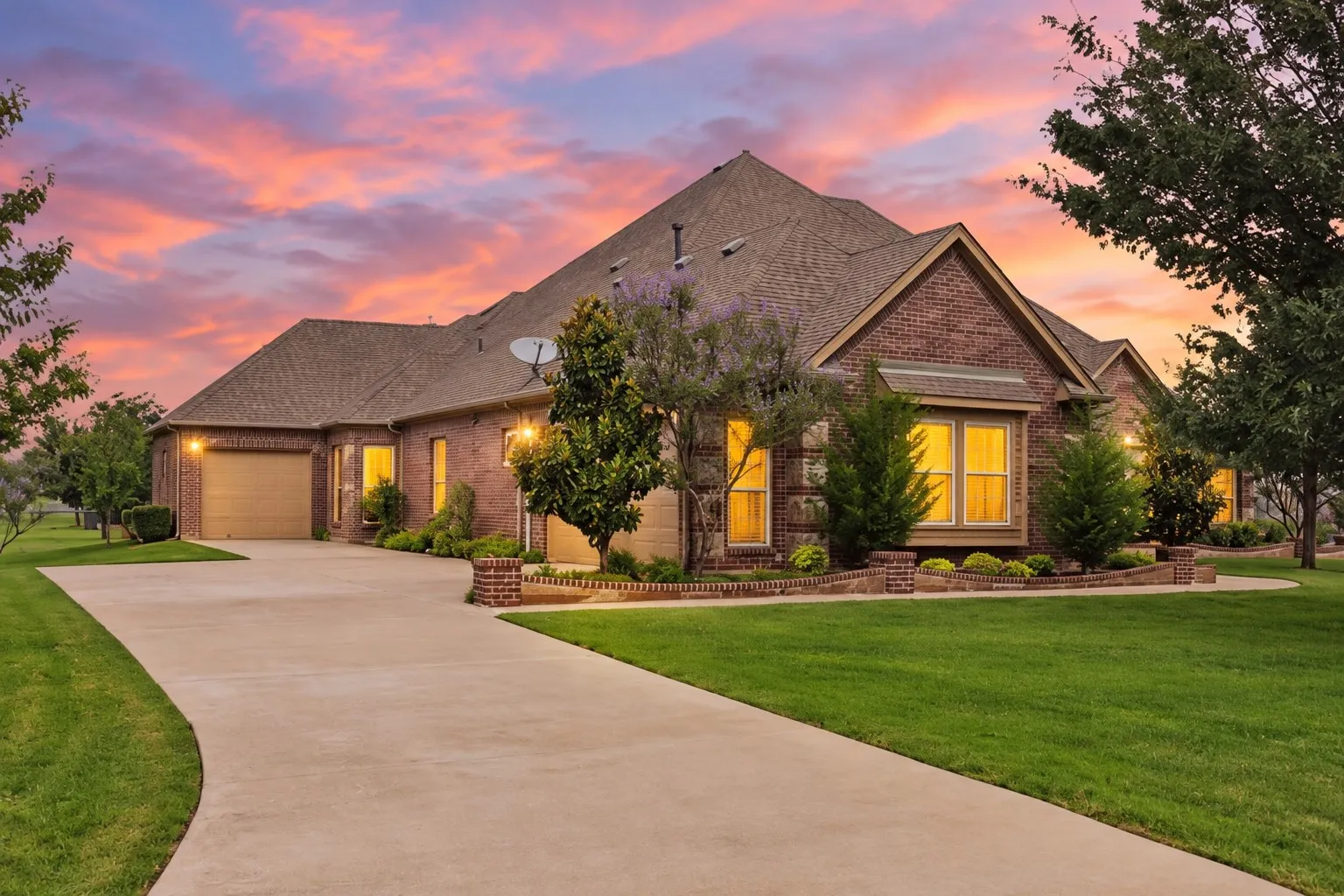 Brick exterior with multiple gables, a concrete driveway, and an attached two-car garage