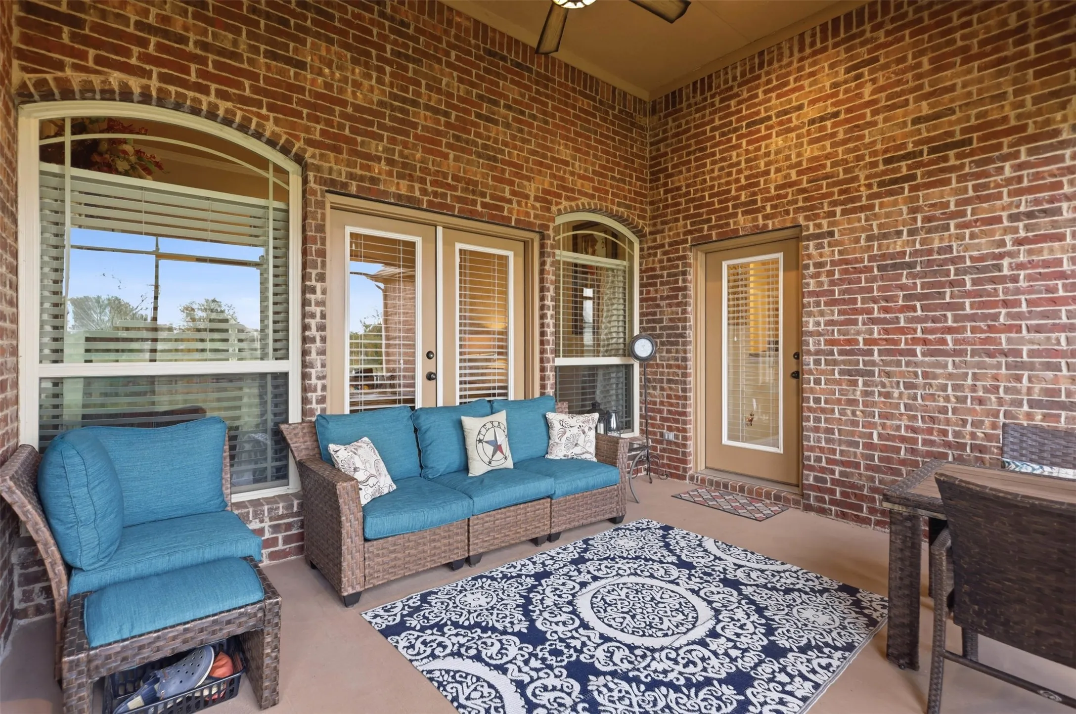 Covered patio with a brick exterior and a concrete slab
