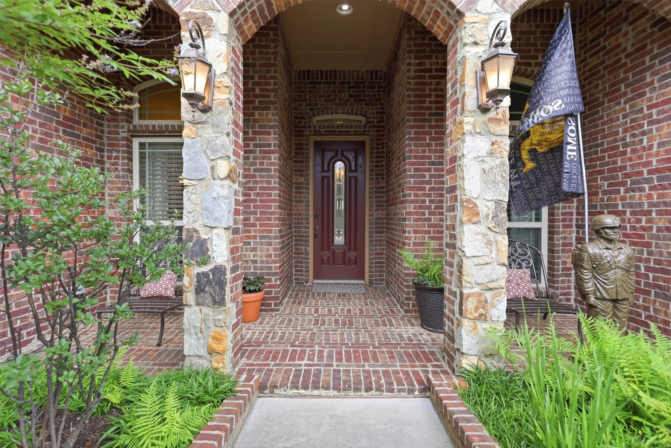 Inviting brick and stone facade featuring an arched entryway