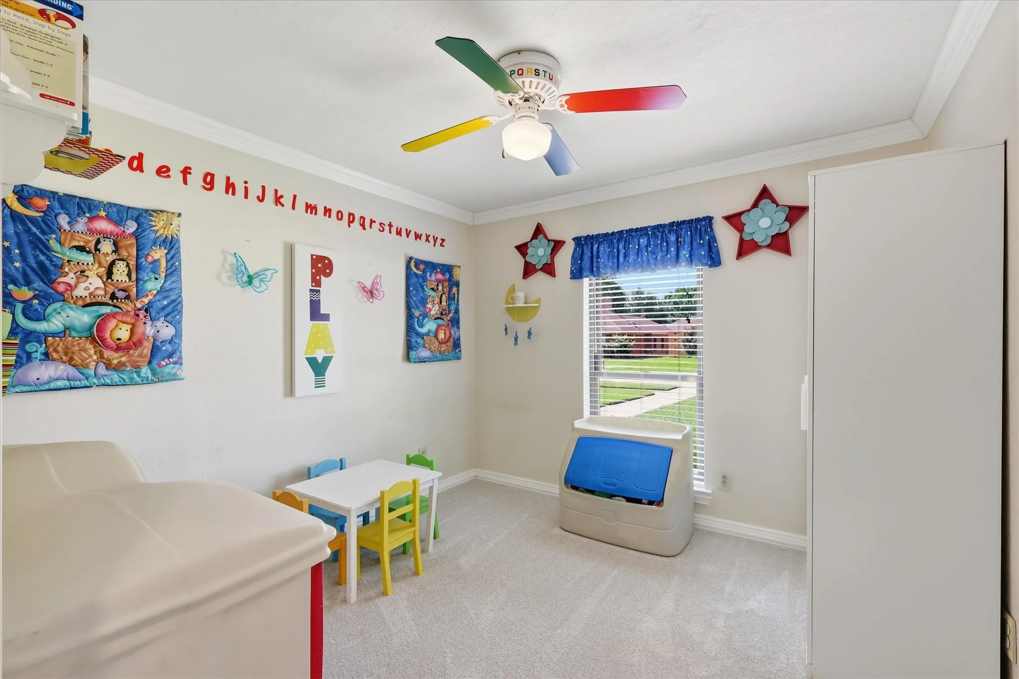 Carpeted room featuring a ceiling fan, crown molding, a window with blinds, and light-colored walls
