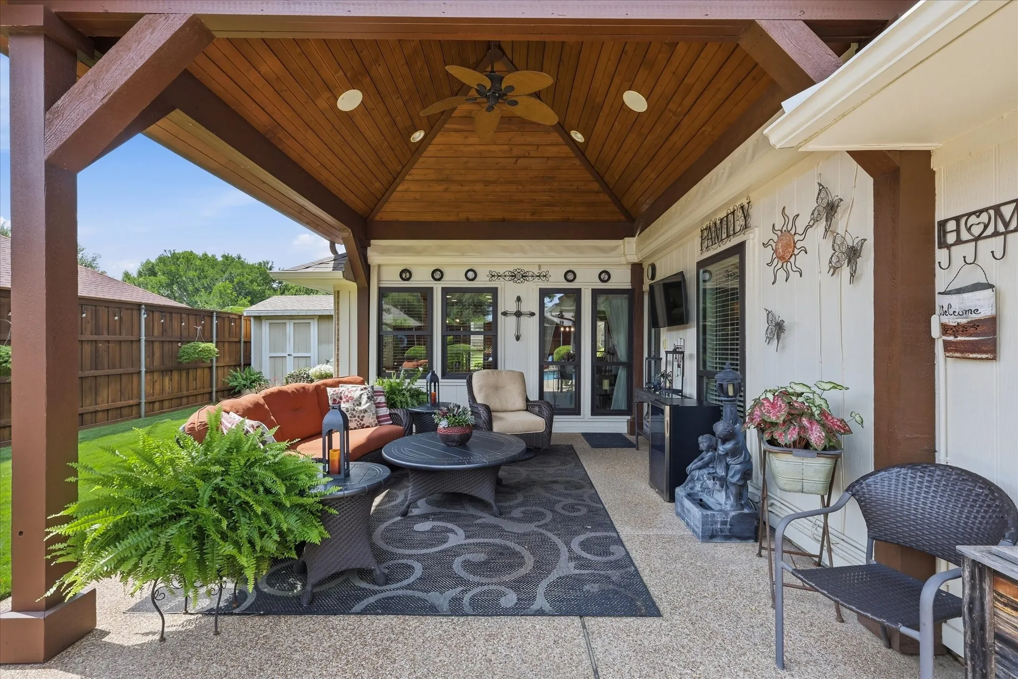 Expansive covered patio featuring a wood-plank ceiling, recessed lighting, and a ceiling fan