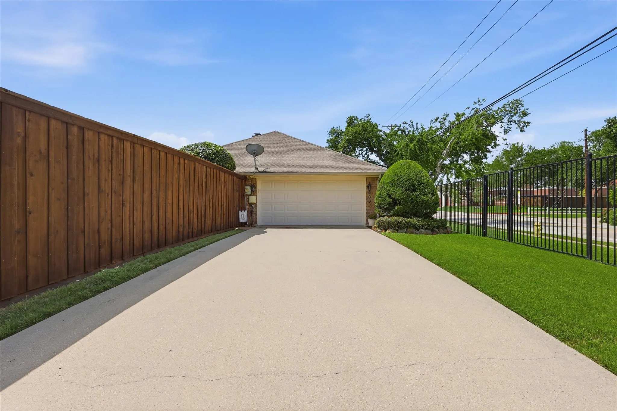 Expansive concrete driveway leading to an attached garage.