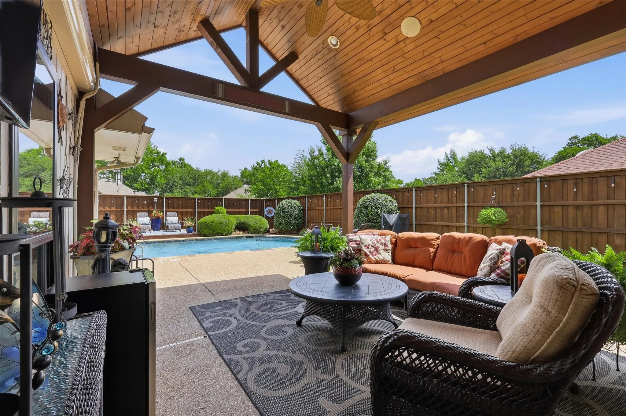 Covered patio featuring an exposed wood plank ceiling, structural wood beams, recessed lighting, and an outdoor ceiling fan