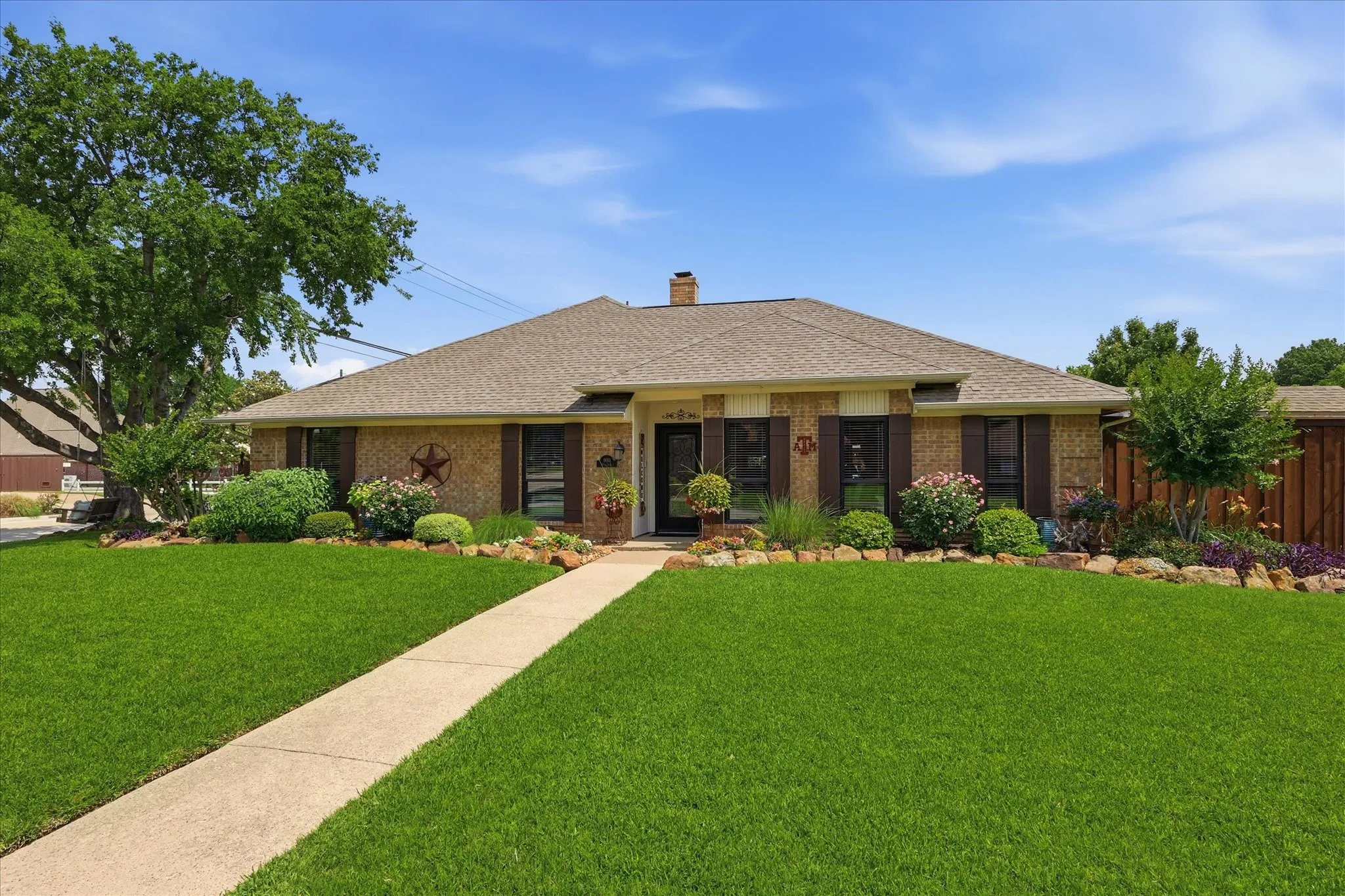Single-story home featuring a brick exterior with dark brown shutters