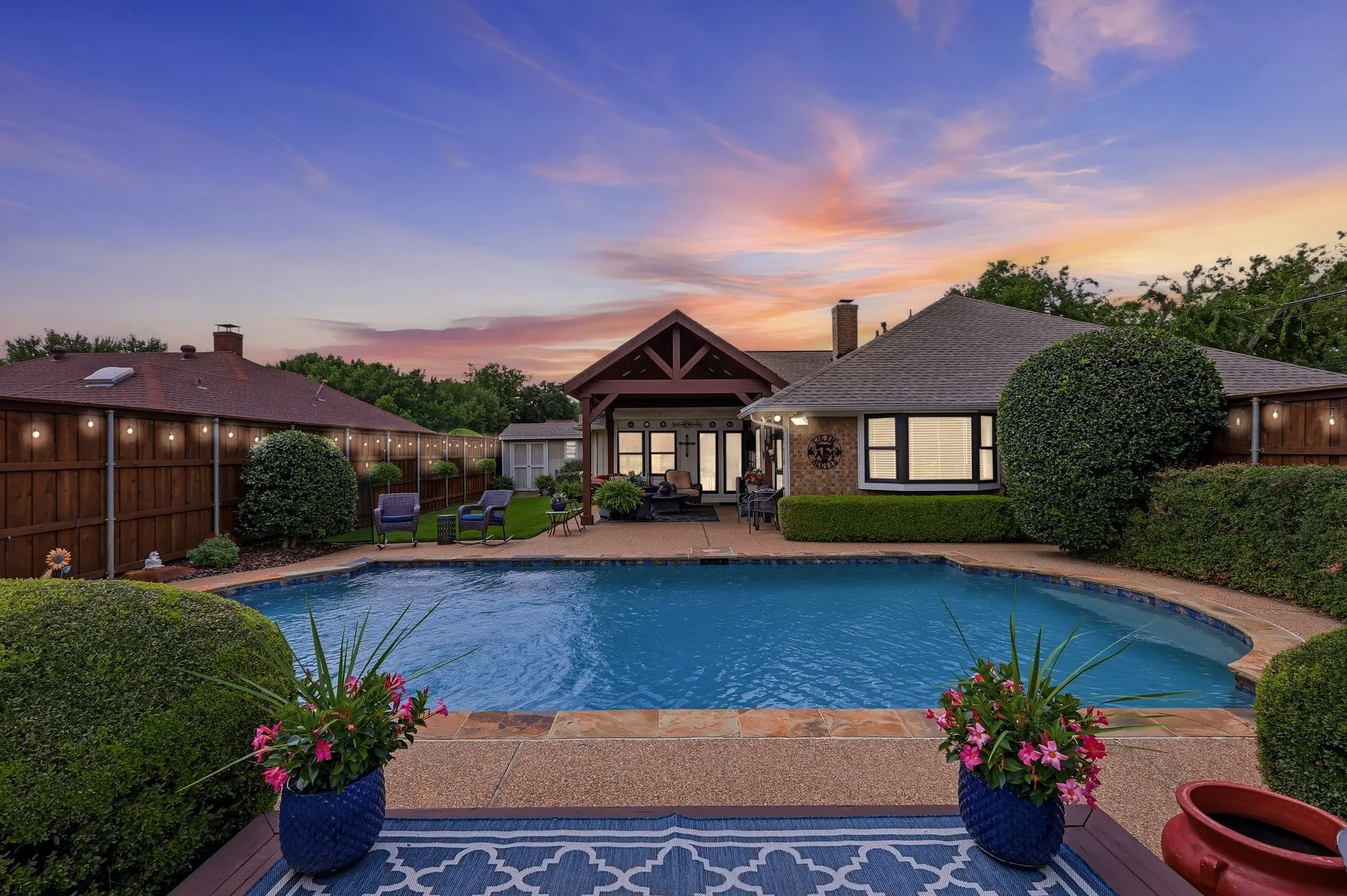 Expansive backyard featuring a curved swimming pool with flagstone coping