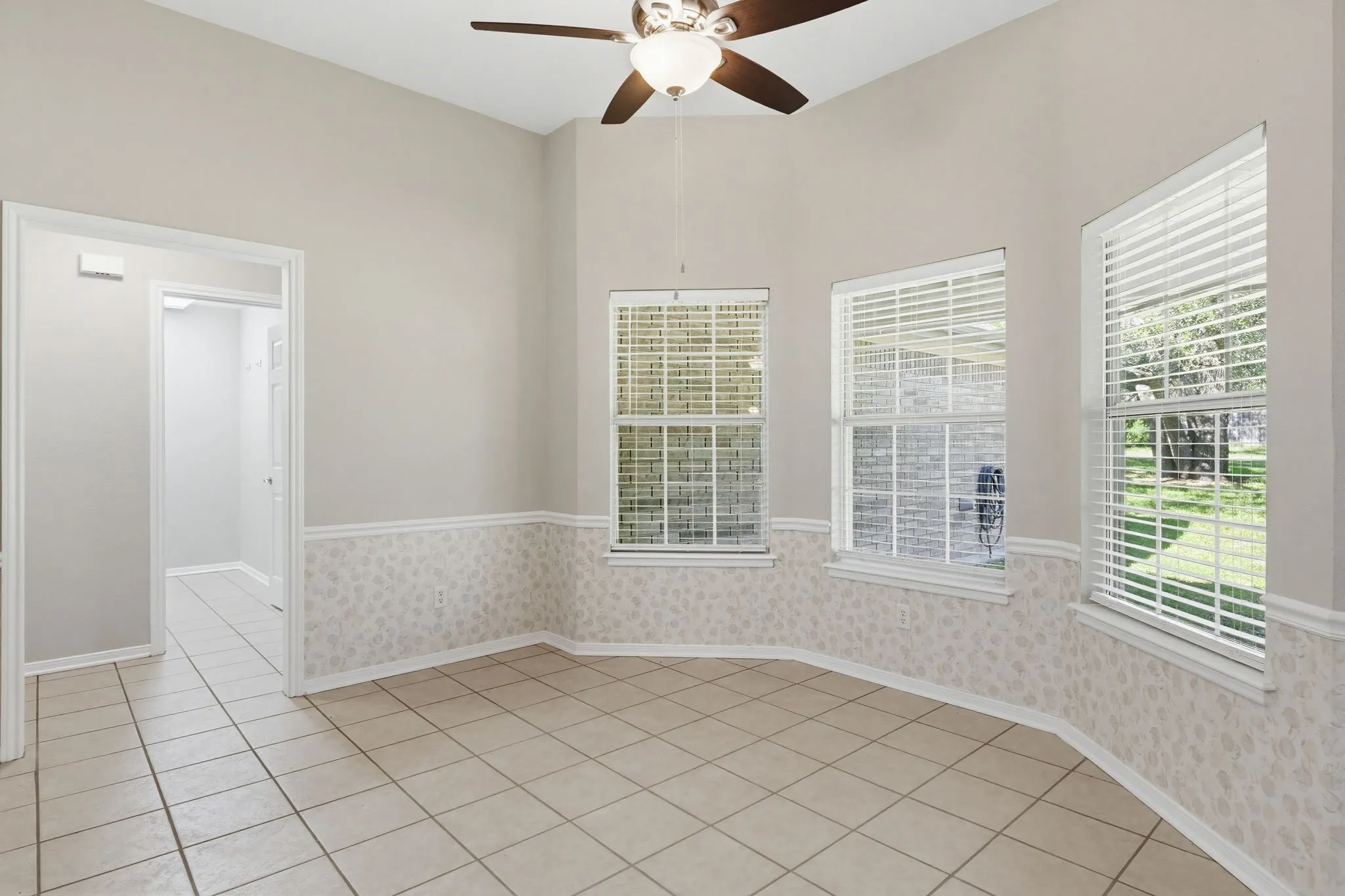 Room featuring tile flooring, vaulted ceilings, and a ceiling fan with light fixture