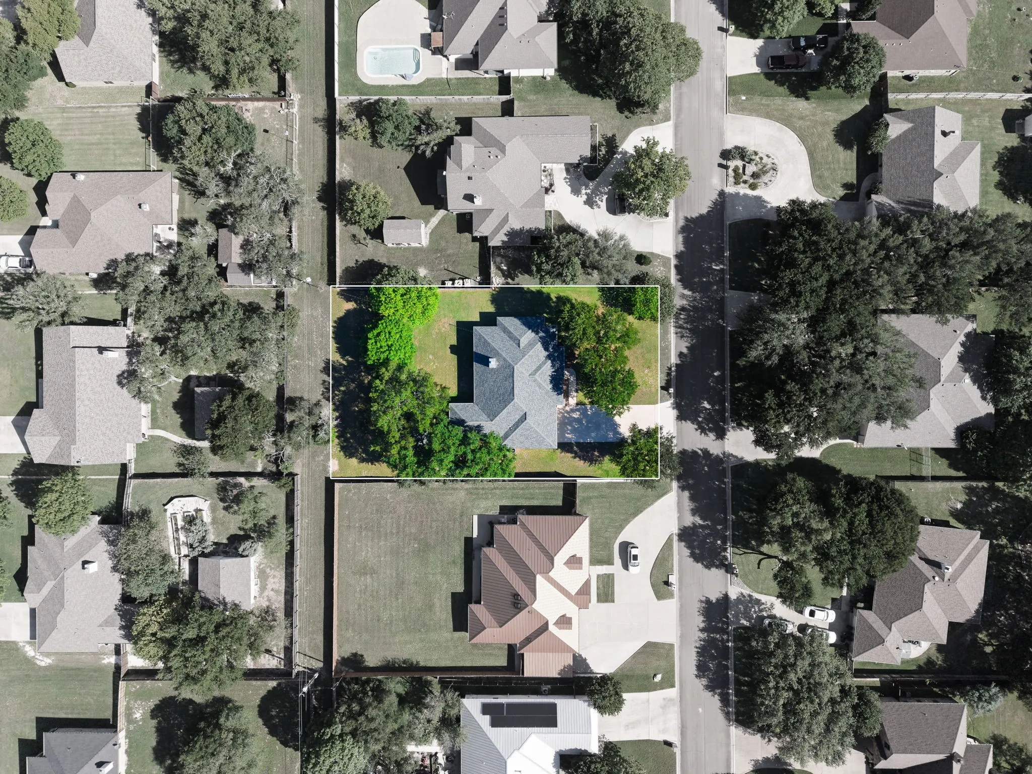 Residential property with a gabled roof and mature trees on a spacious lot