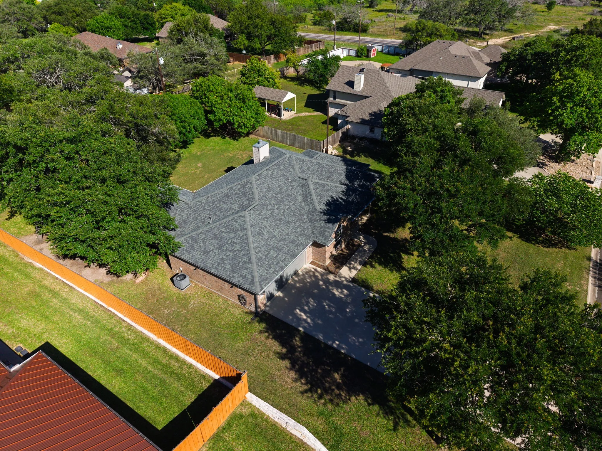 Aerial perspective showcasing the property's roofline, mature trees, and landscaping