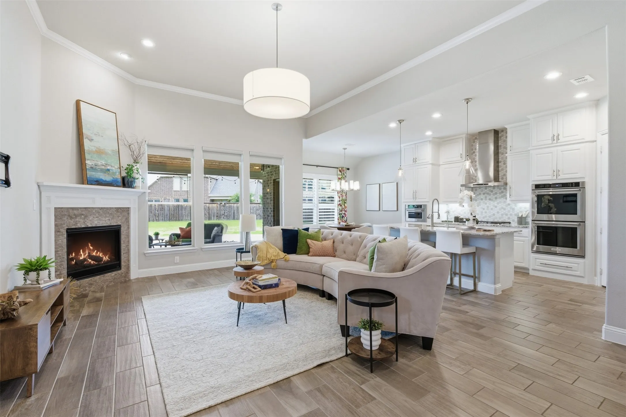 Open-concept living area with wood-finish flooring and a contemporary fireplace