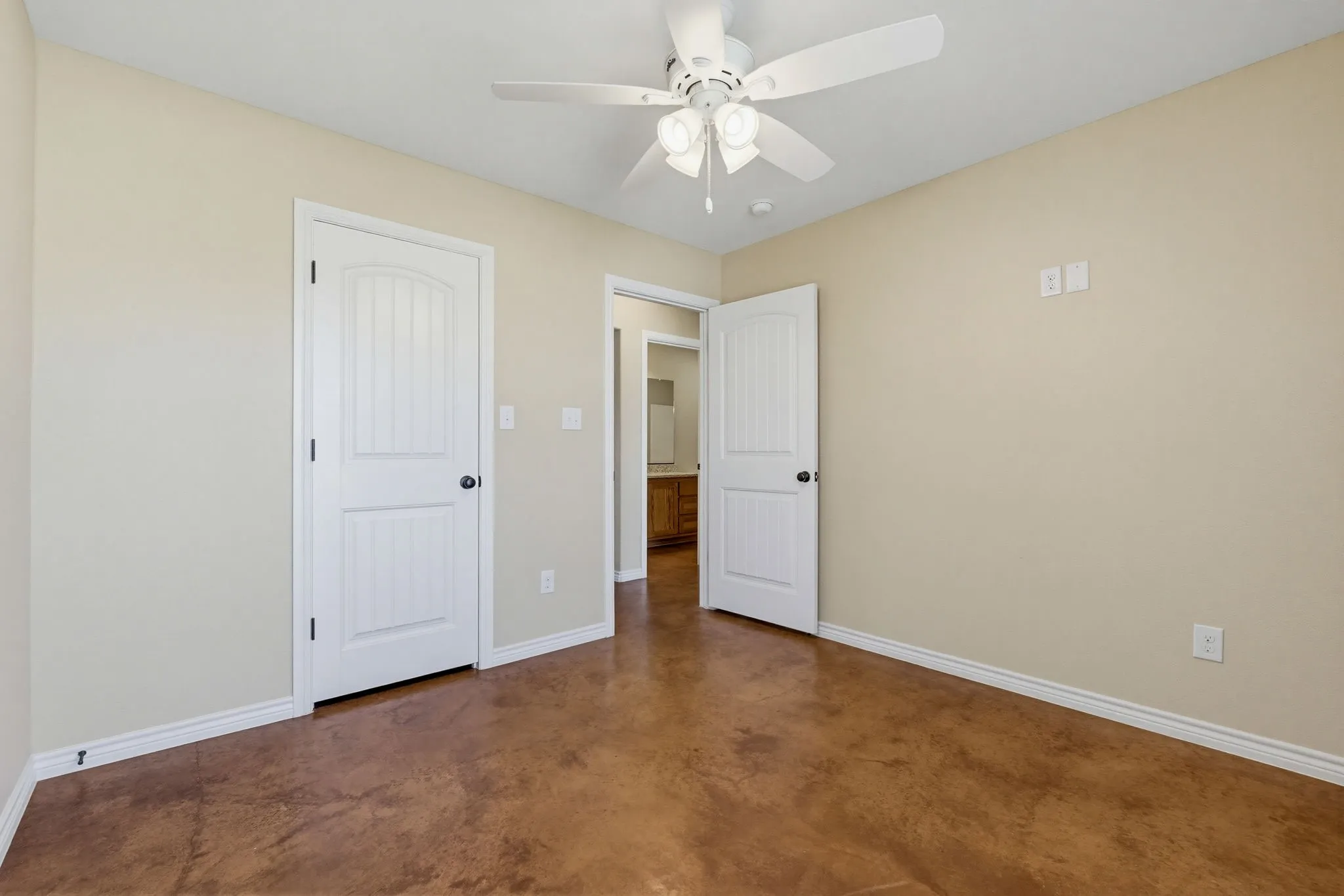 Interior room featuring brown-toned flooring and light beige walls