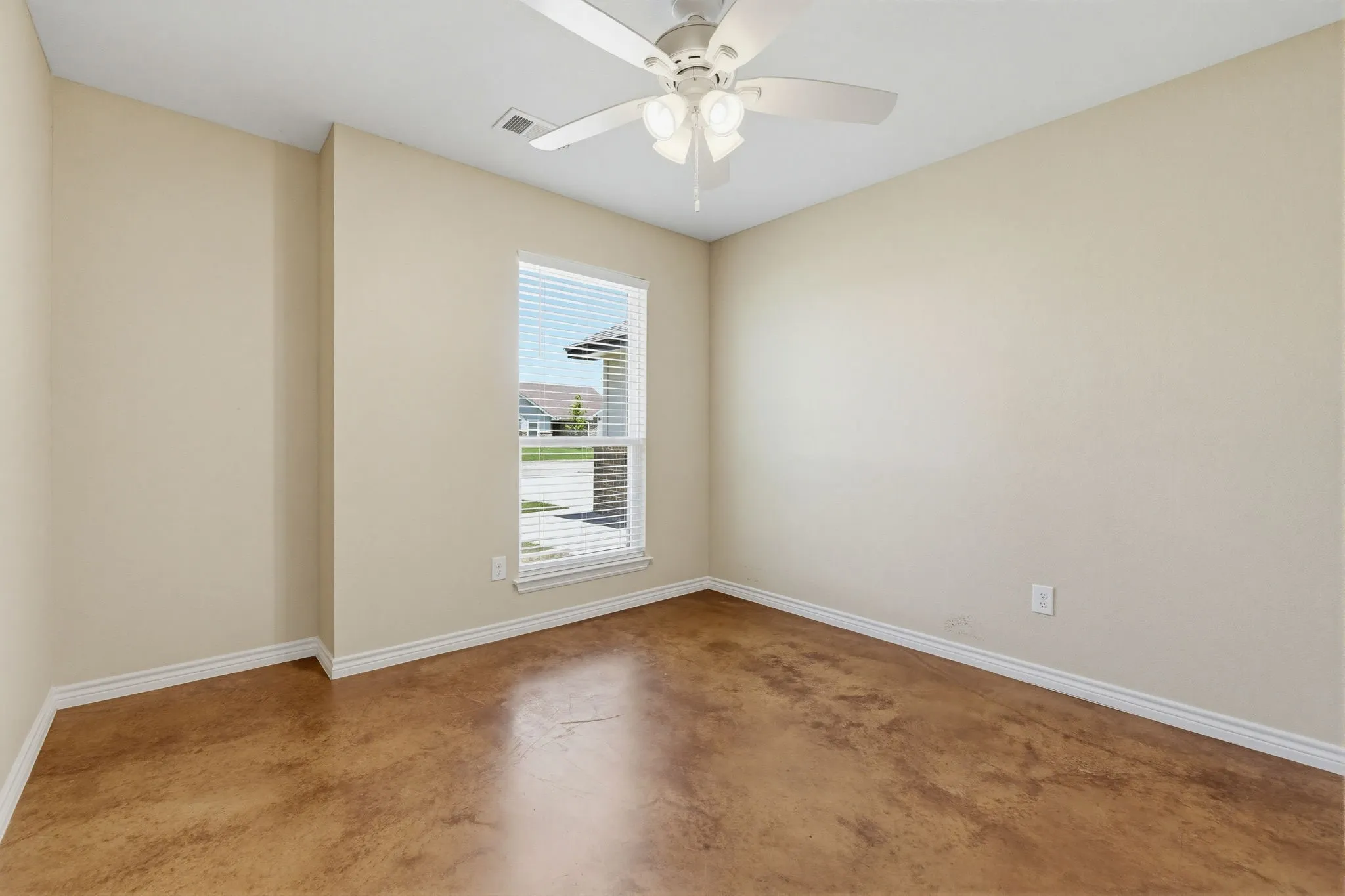 Interior room featuring a white ceiling fan with integrated lighting, a window with blinds, and stained concrete flooring