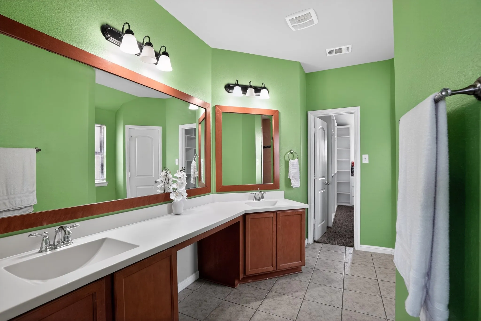 Bathroom featuring a double vanity with integrated sinks, ample countertop space, and wood-finish cabinetry