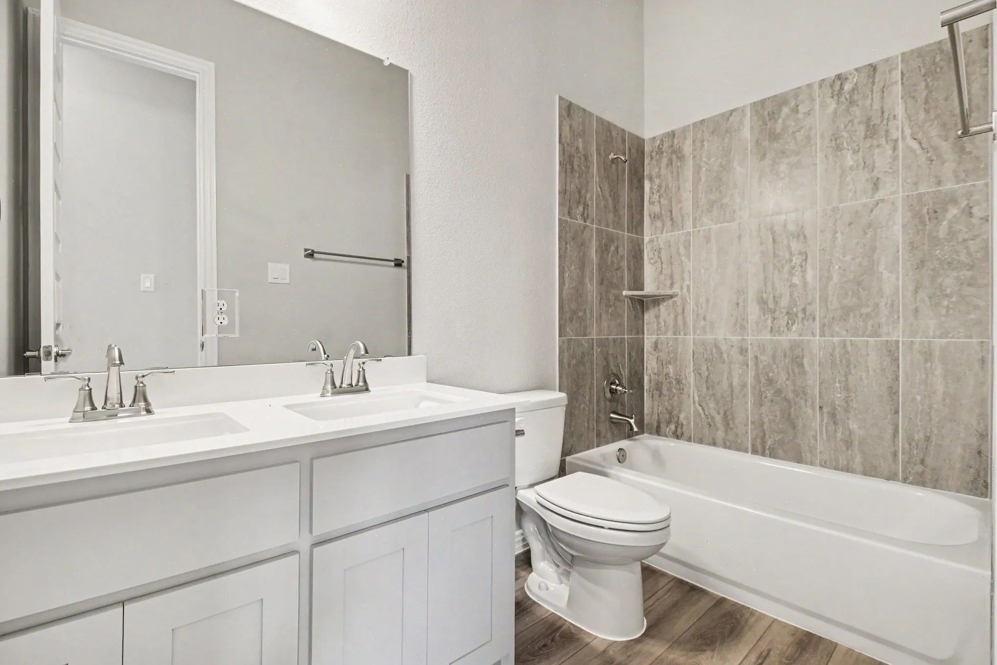 Bathroom featuring a double vanity with white cabinetry, dual sinks, and a large mirror