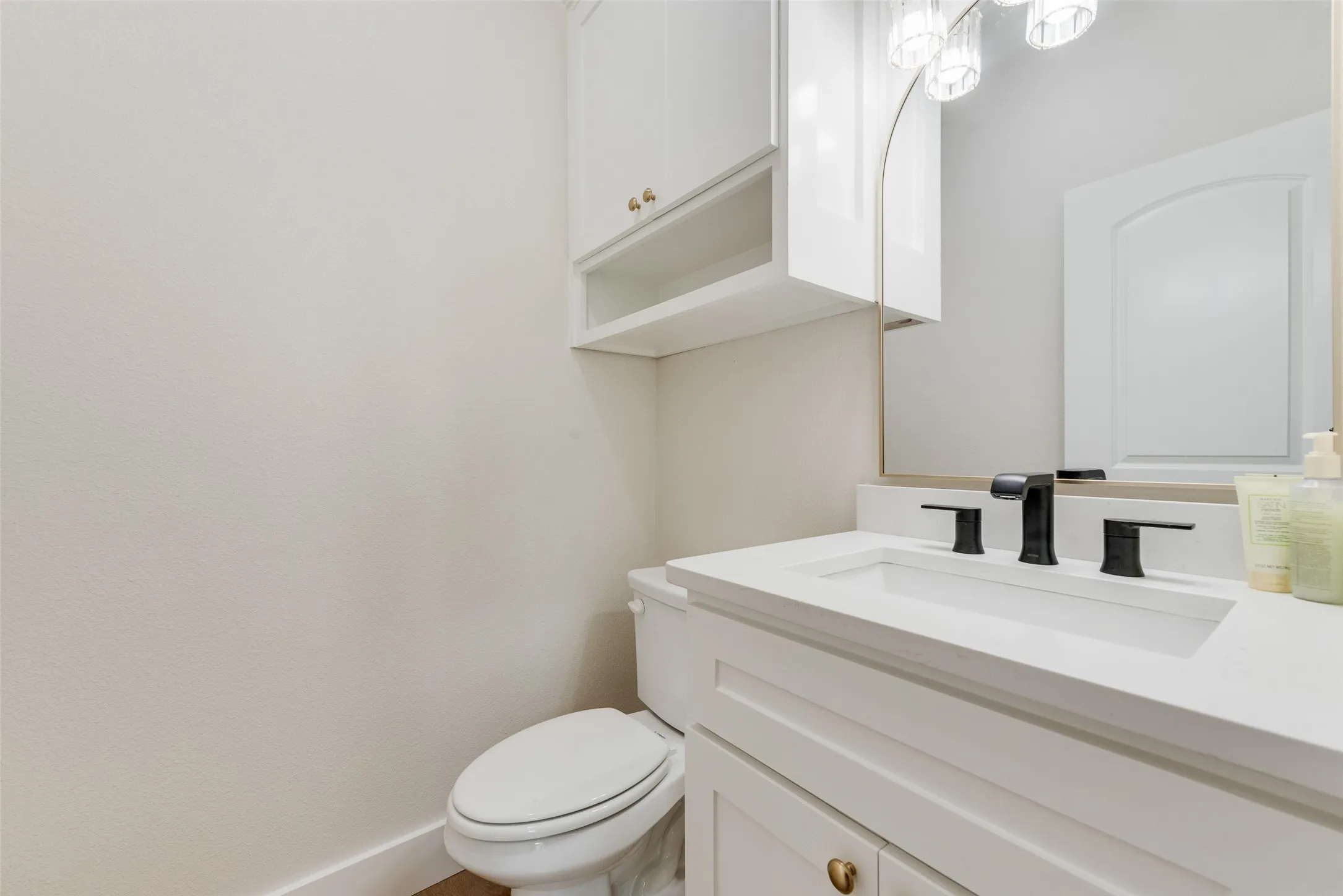 White vanity with an integrated rectangular sink, matte black faucet, and white countertop