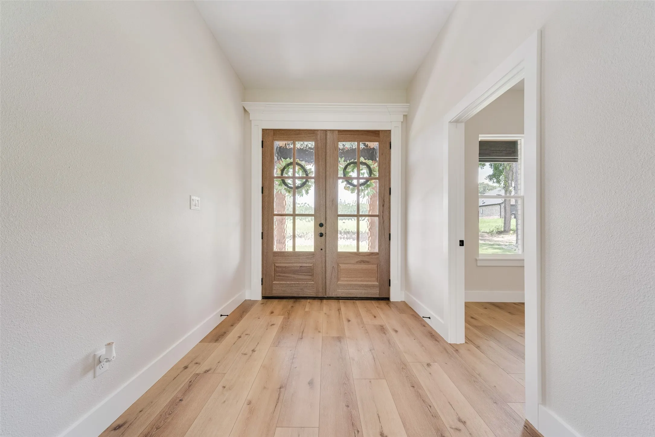 Double entry doors with glass panels and natural wood finish