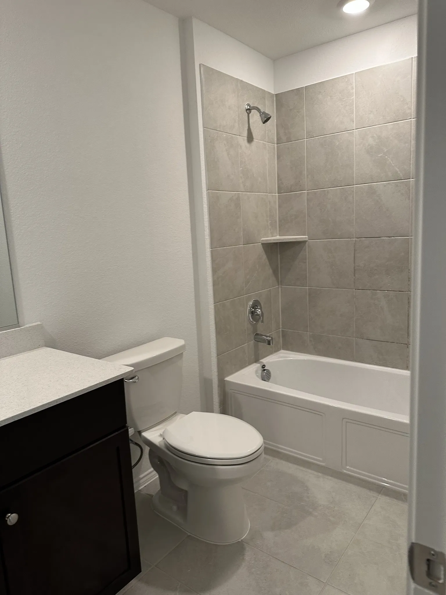 Full bathroom featuring tile patterned flooring, tiled shower / bath, vanity, and toilet