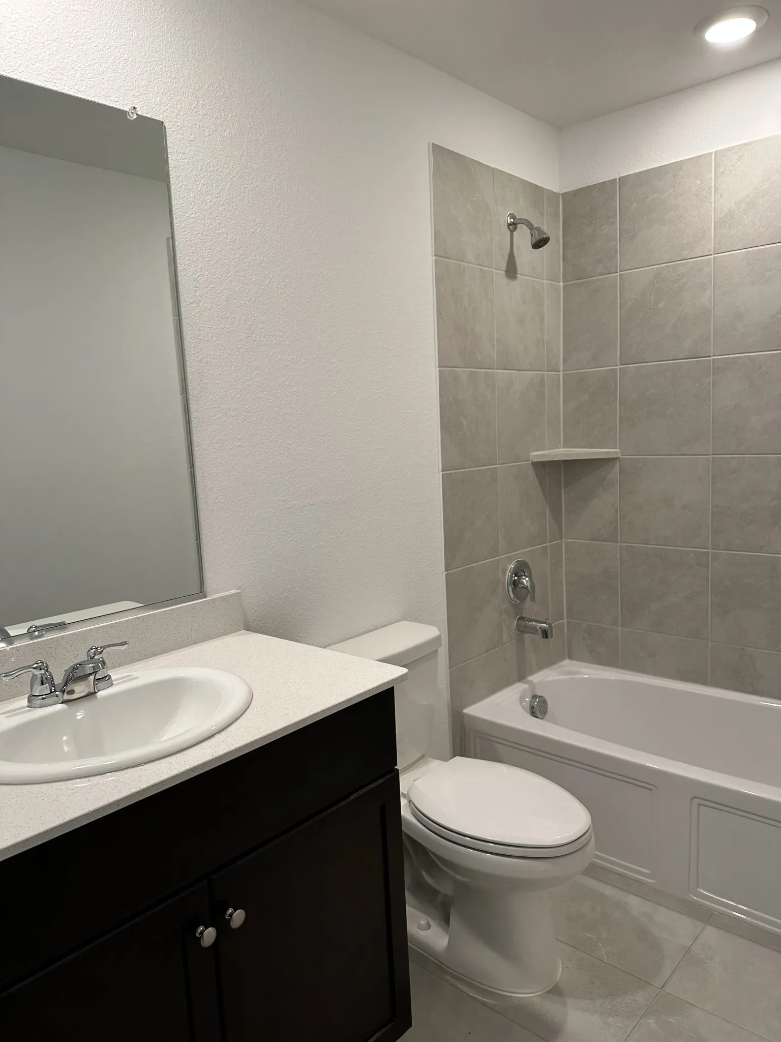 Full bathroom with vanity, tile patterned flooring, toilet, and tiled shower / bath