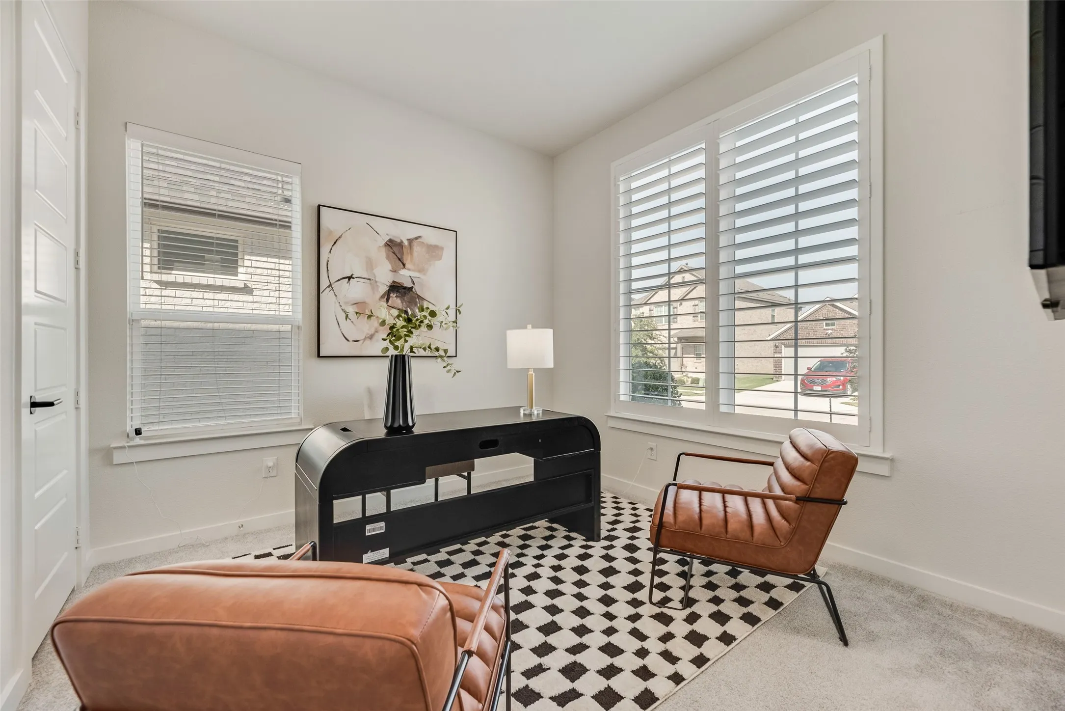 Bright room that is just off the foyer, that is also great for added privacy to guests or for at home office use, featuring neutral paint and plantation shutters