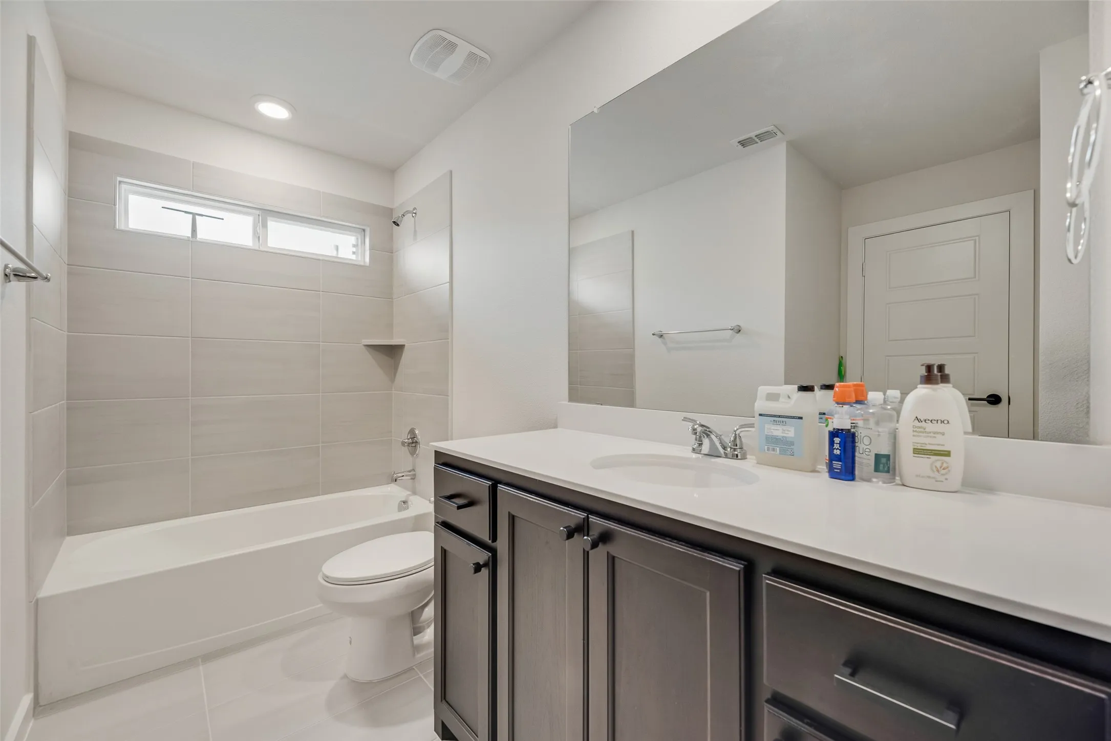 Bathroom featuring a dark wood-finish vanity with a light countertop and an integrated sink