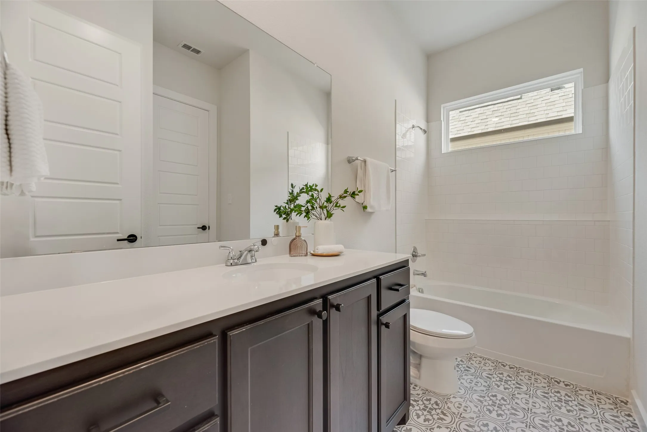 Bathroom featuring a dark wood vanity with a white countertop, an undermount sink, and chrome fixtures