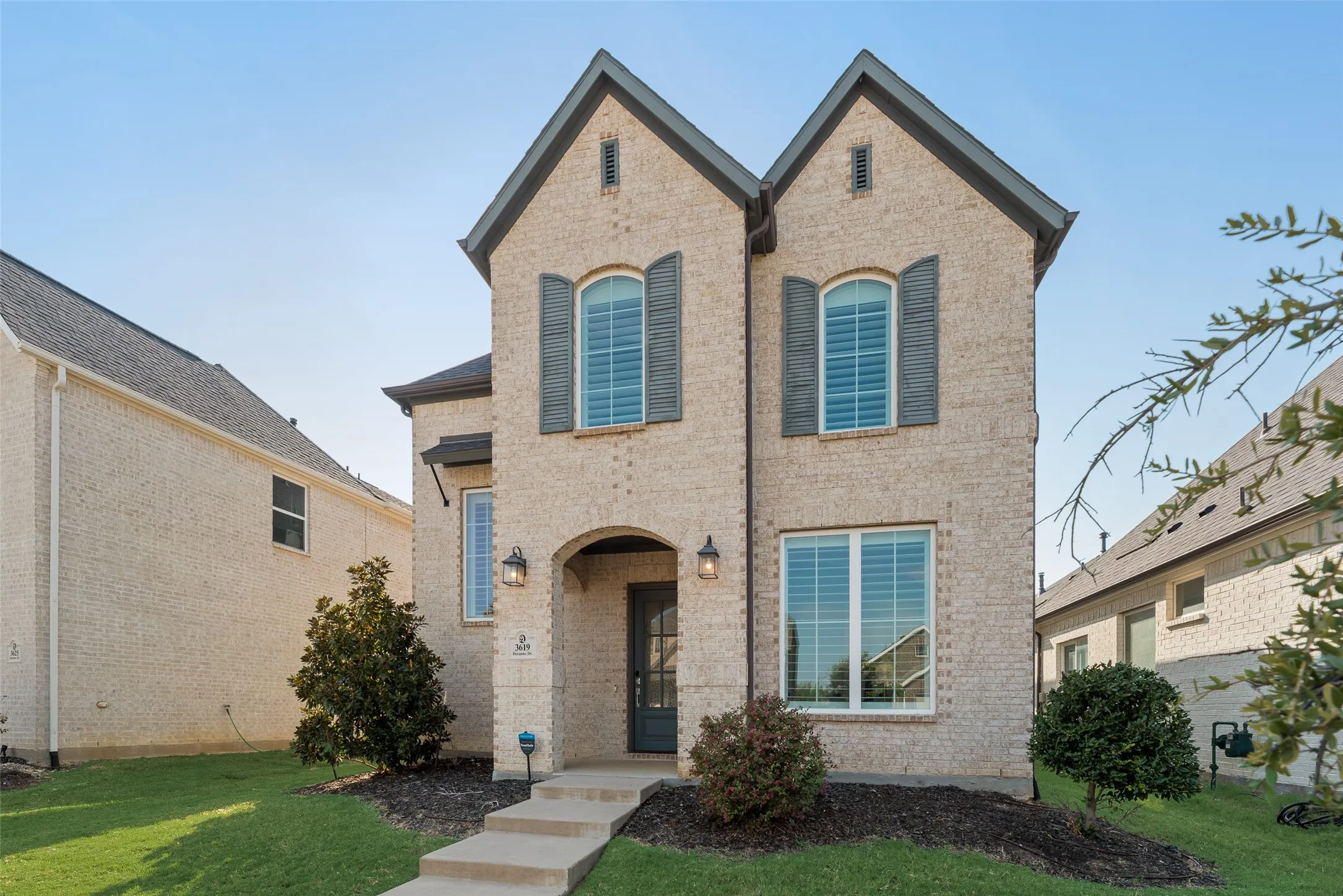 Brick exterior featuring a gabled roofline and arched entry
