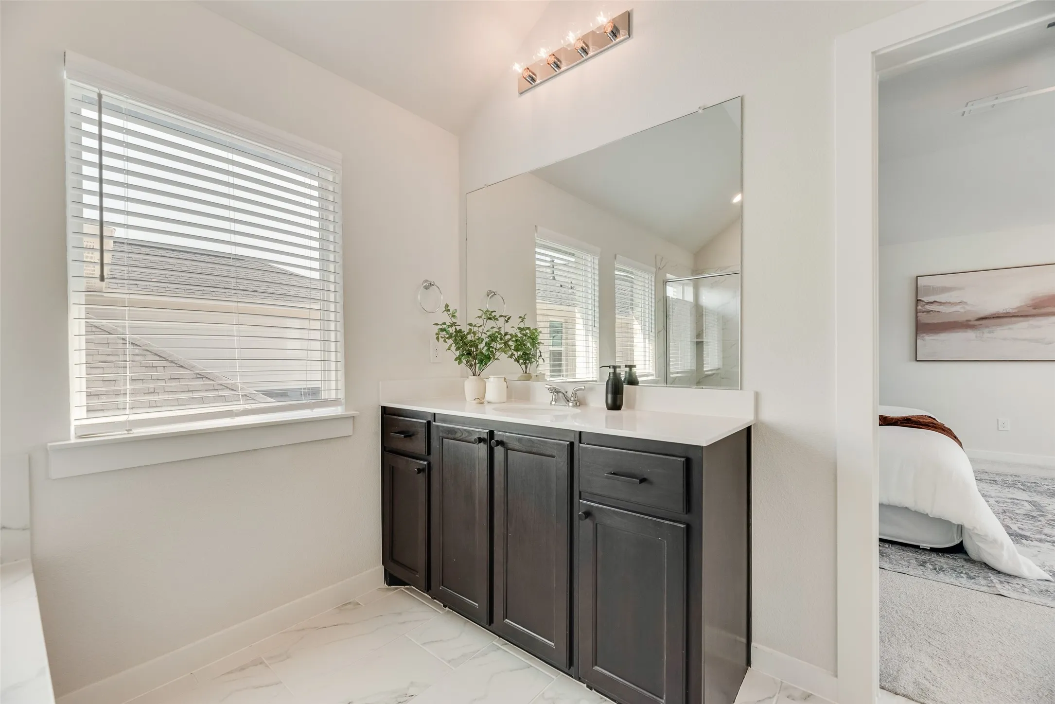 Bathroom vanity featuring dark wood cabinetry, a light countertop, and a large wall-mounted mirror
