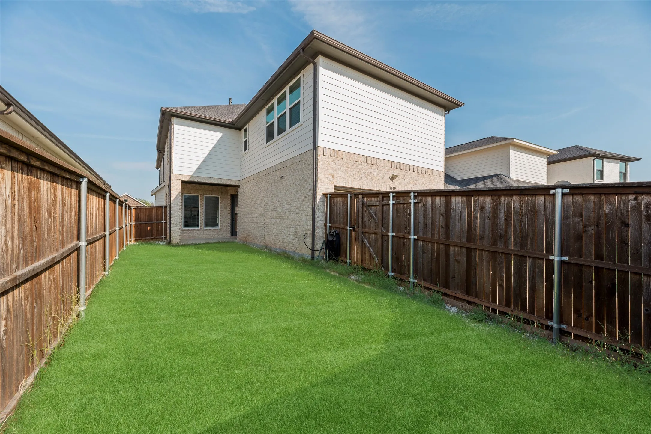 Expansive grassy yard featuring a wood privacy fence
