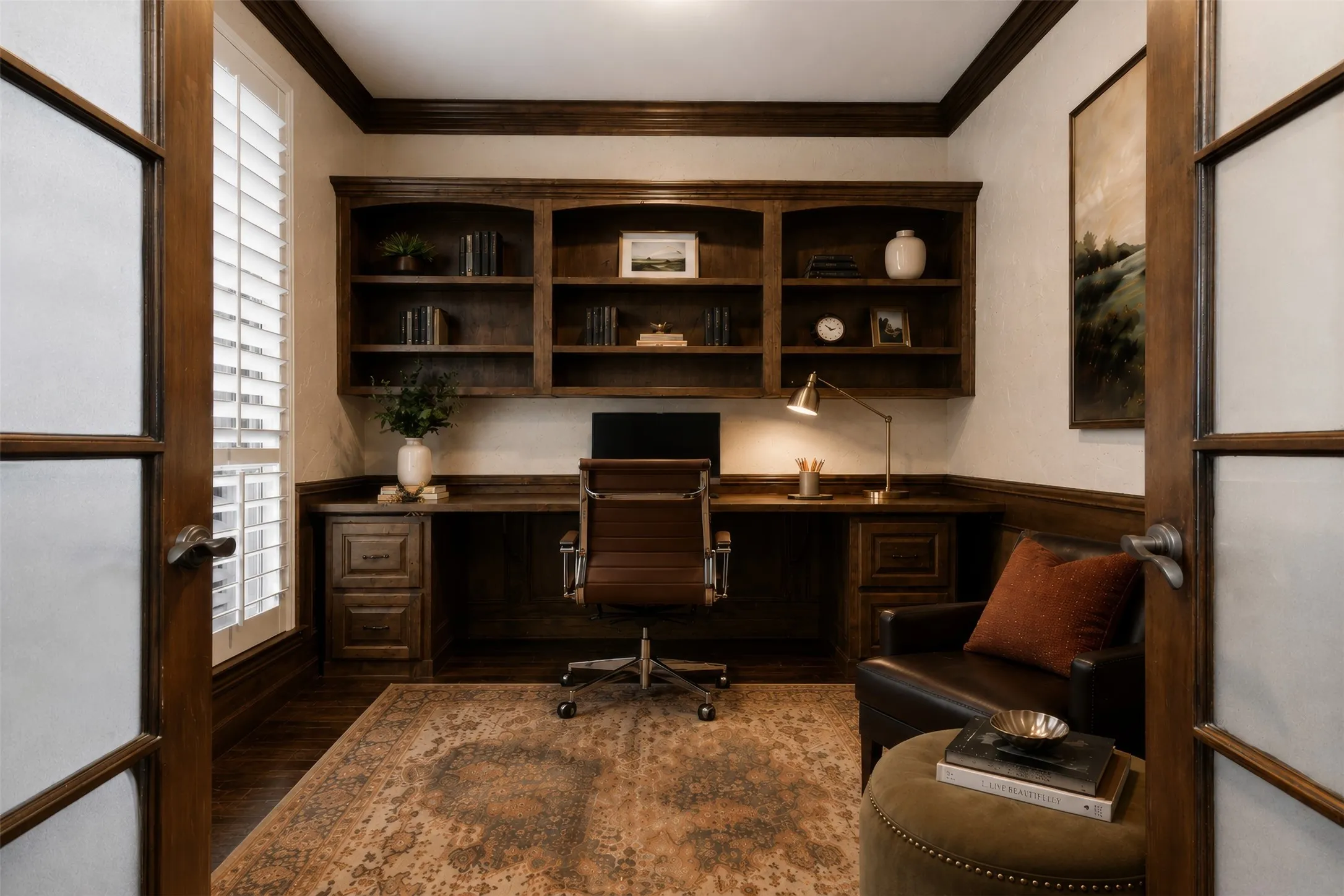 Dedicated study featuring rich wood-finish built-in cabinetry, integrated desk space, wood-finish flooring, and crown molding