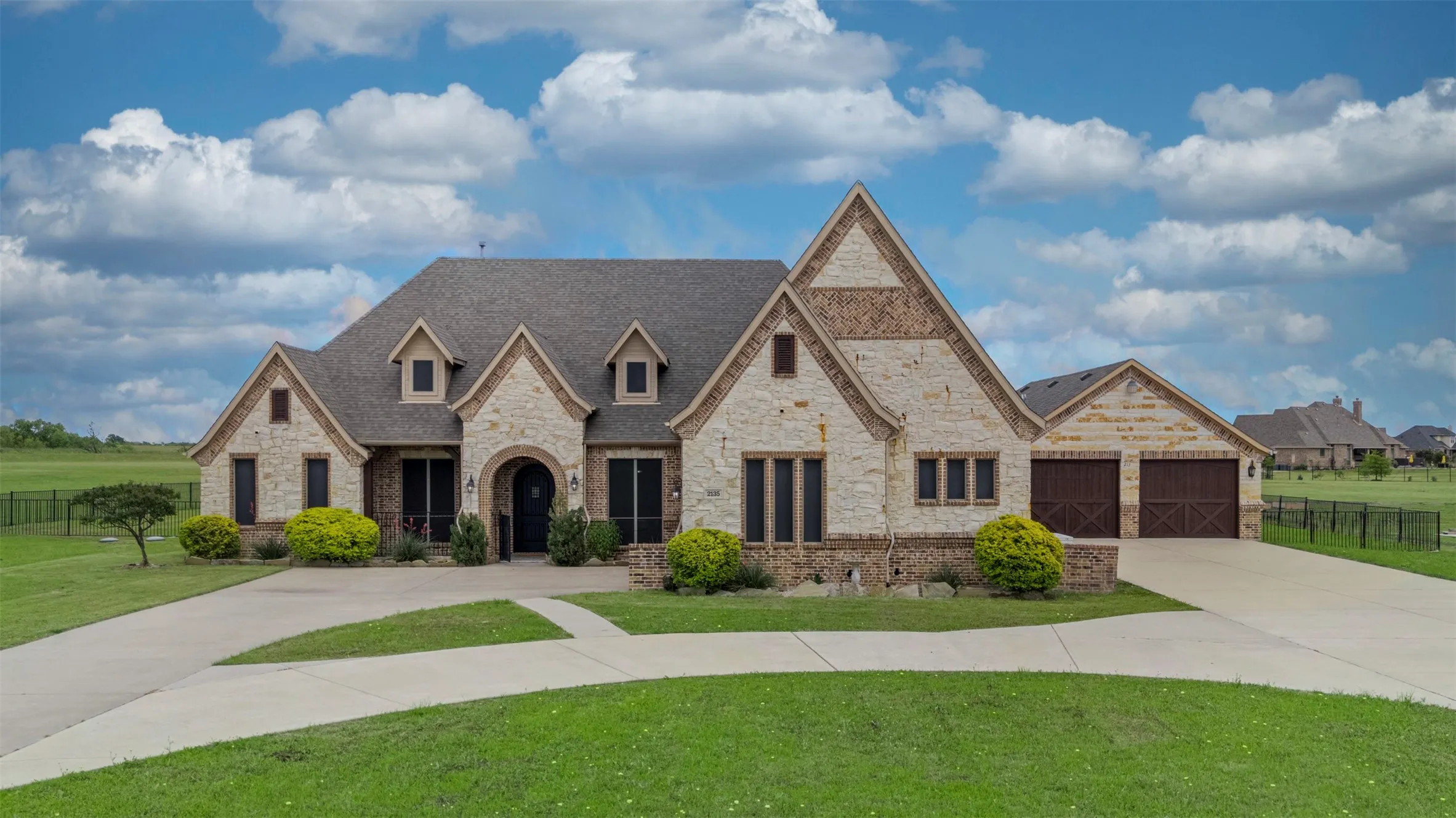 Expansive rear yard featuring a freeform swimming pool with integrated spa, a paved patio surround, and a winding stone pathway