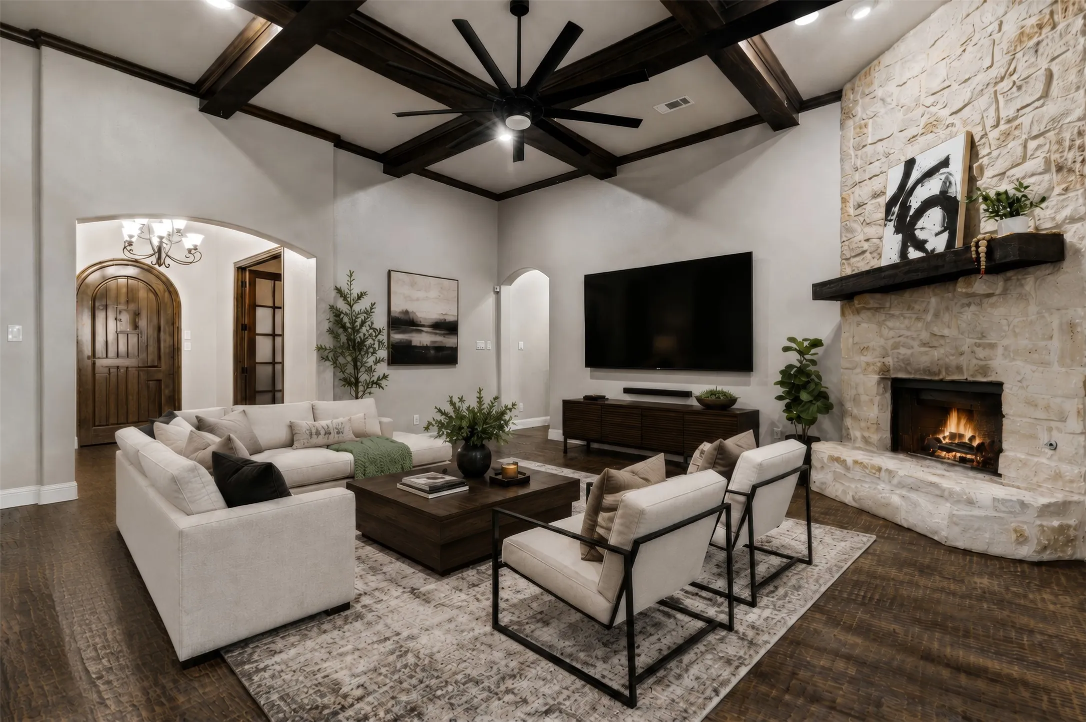 Vaulted ceiling featuring dark wood-finish beams and a large ceiling fan